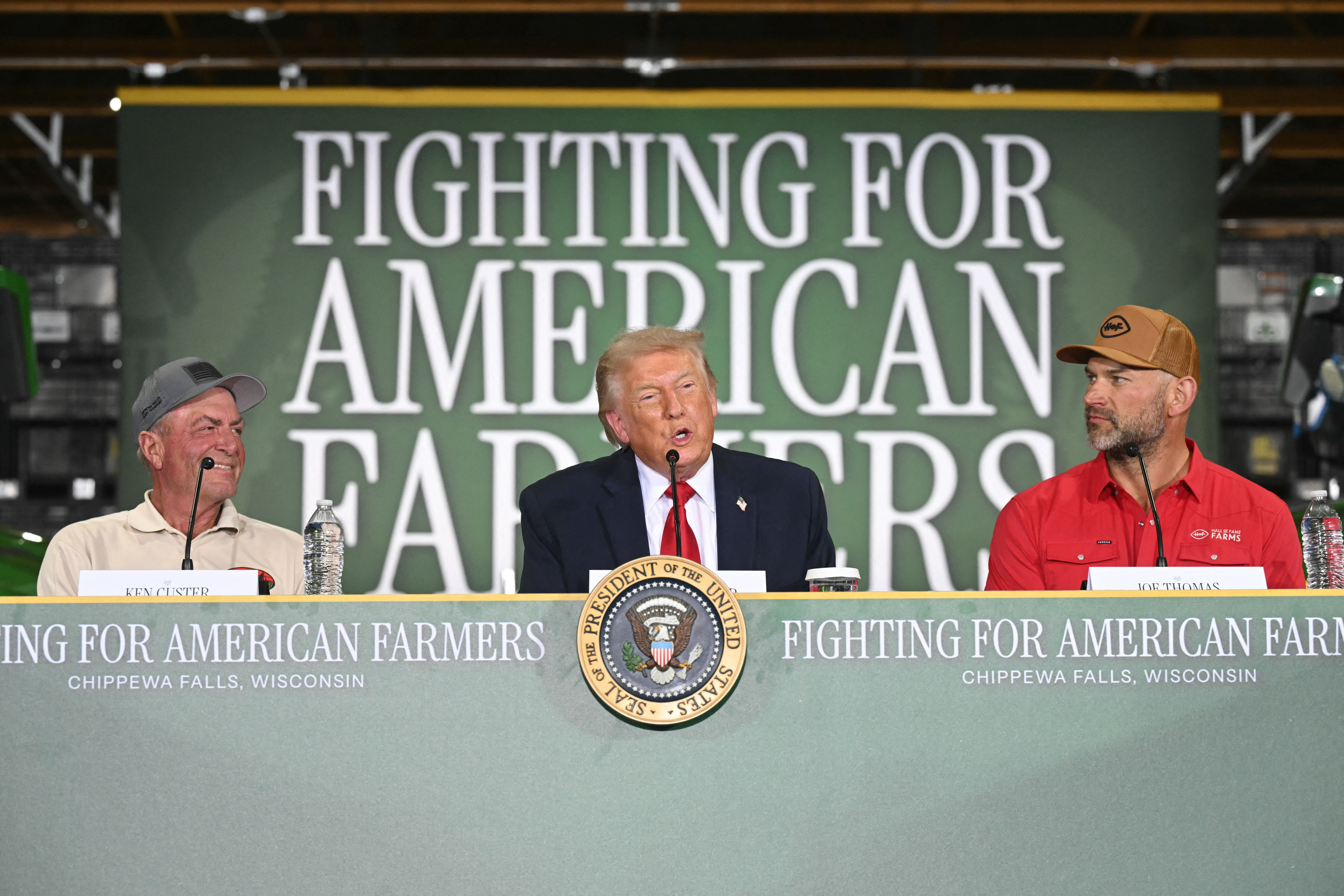 US President Donald Trump (C) speaks, flanked by Custer Farms owner Ken Custer (L) and Hall of Fame Farms owner Joe Thomas (R), during a roundtable on "American Agriculture" at Custer Farms in Chippewa Falls, Wisconsin, on June 5, 2026.
