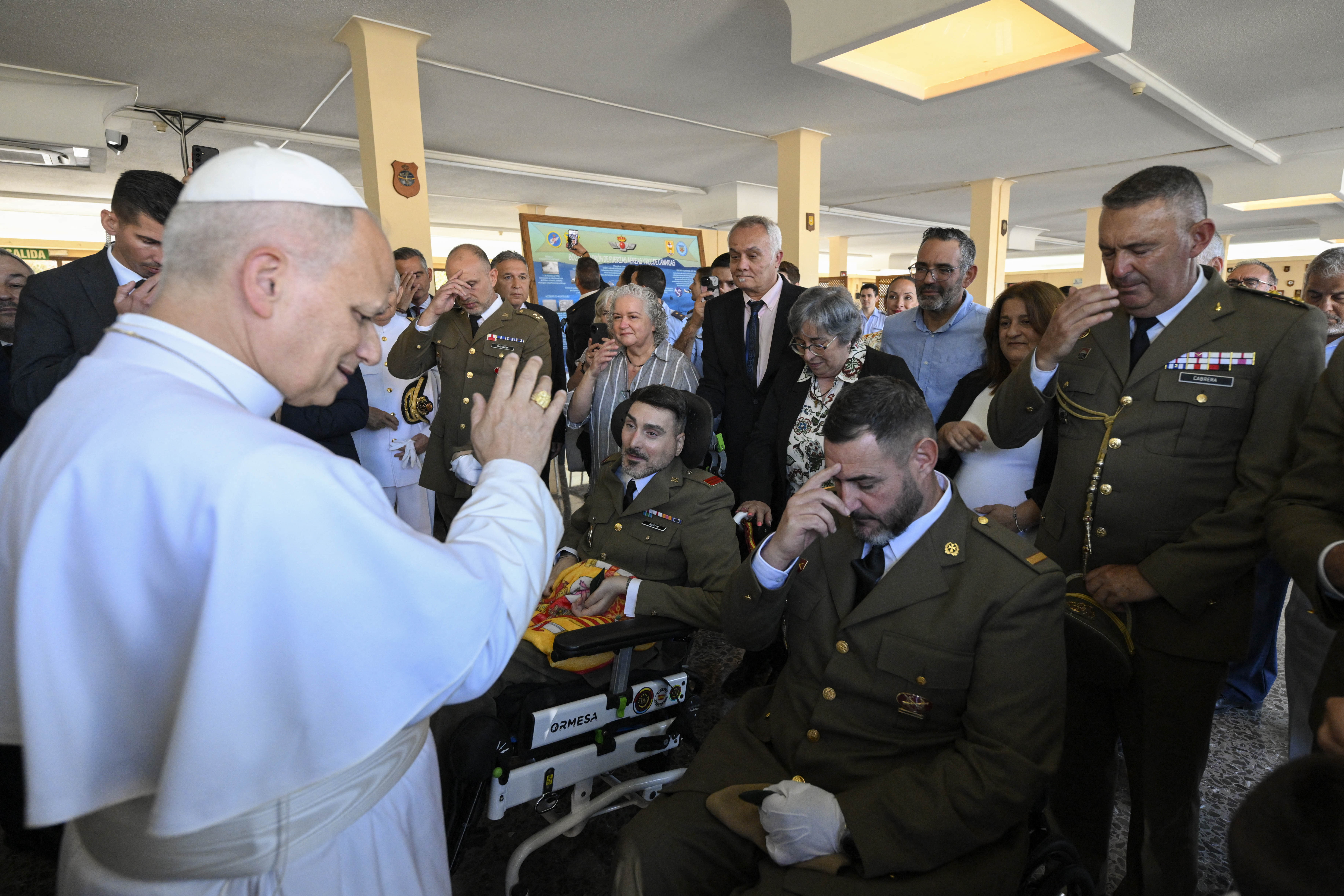 This handout photo taken and released on June 11, 2026 by The Vatican Media shows Pope Leo XIV giving his blessing to a group of military personnel after arriving in the Gando Air base in Telde, on the Canary island of Gran Canaria, on June 11, 2026.