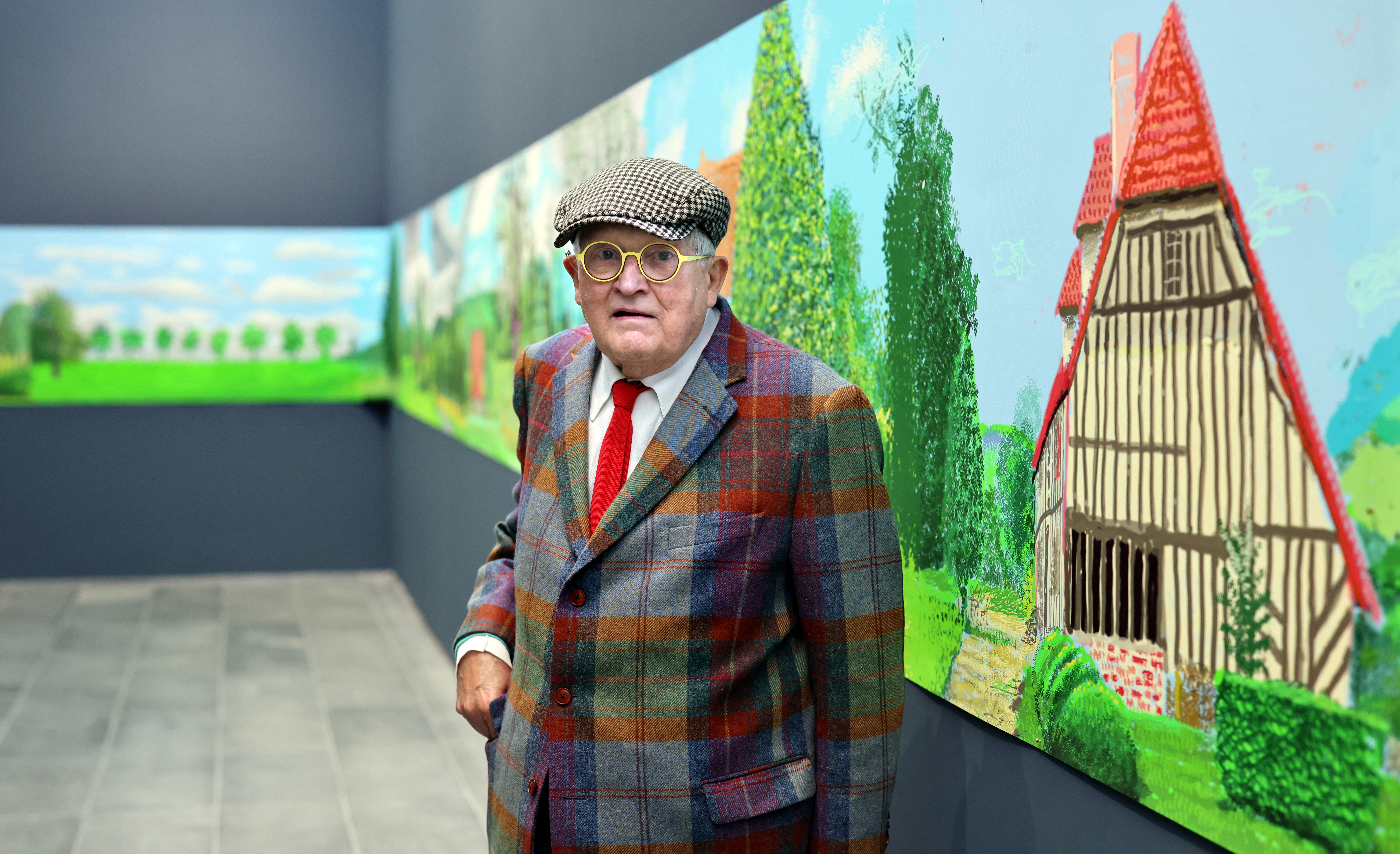 British painter David Hockney poses in front of his painting, A Year in Normandy.