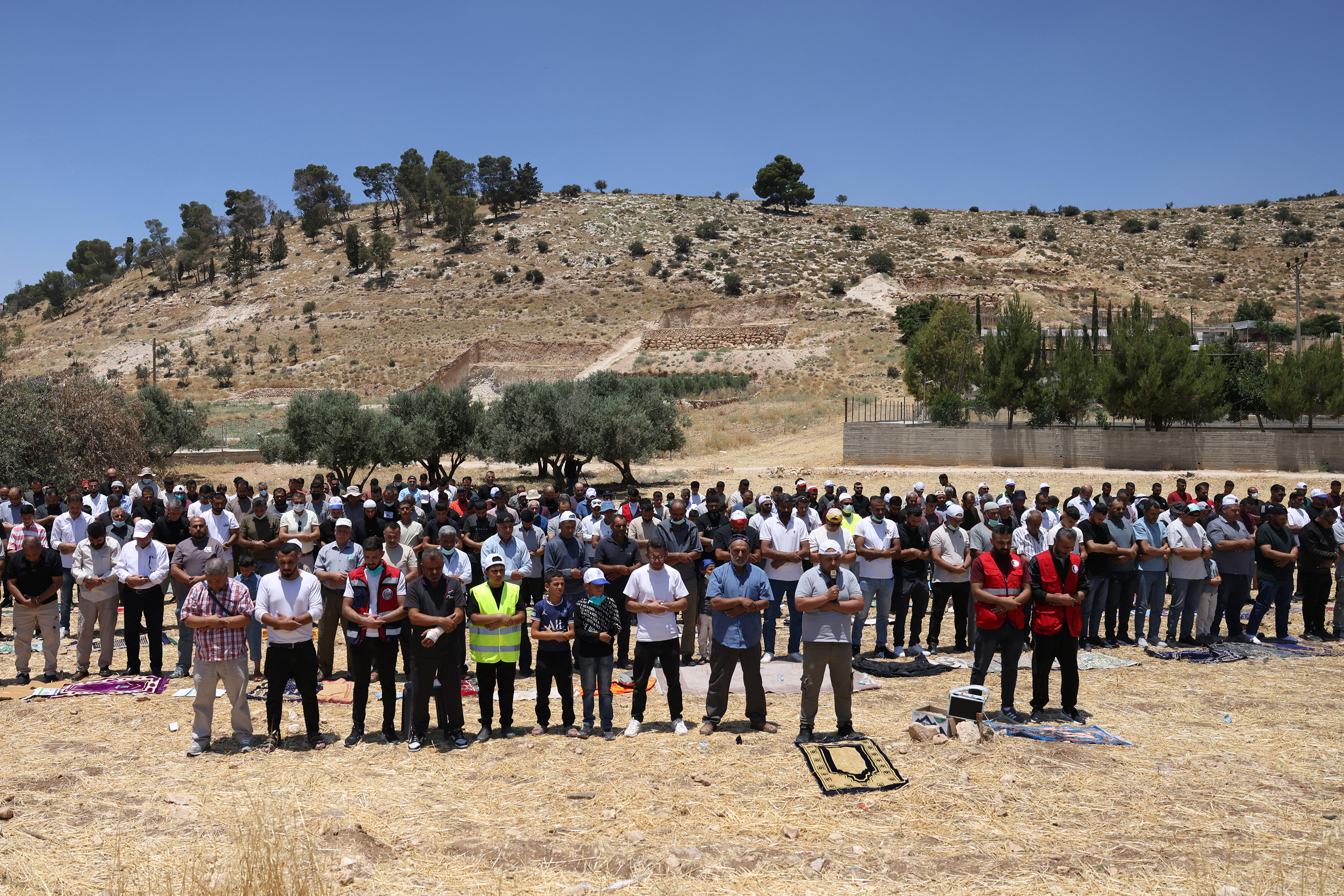 Palestinian men, who had gathered to protest threats of confiscation of their land, perform the Muslim Friday noon prayers at a field in the Palestinian village of Idna, west of Hebron in the occupied West Bank, on June 12, 2026.