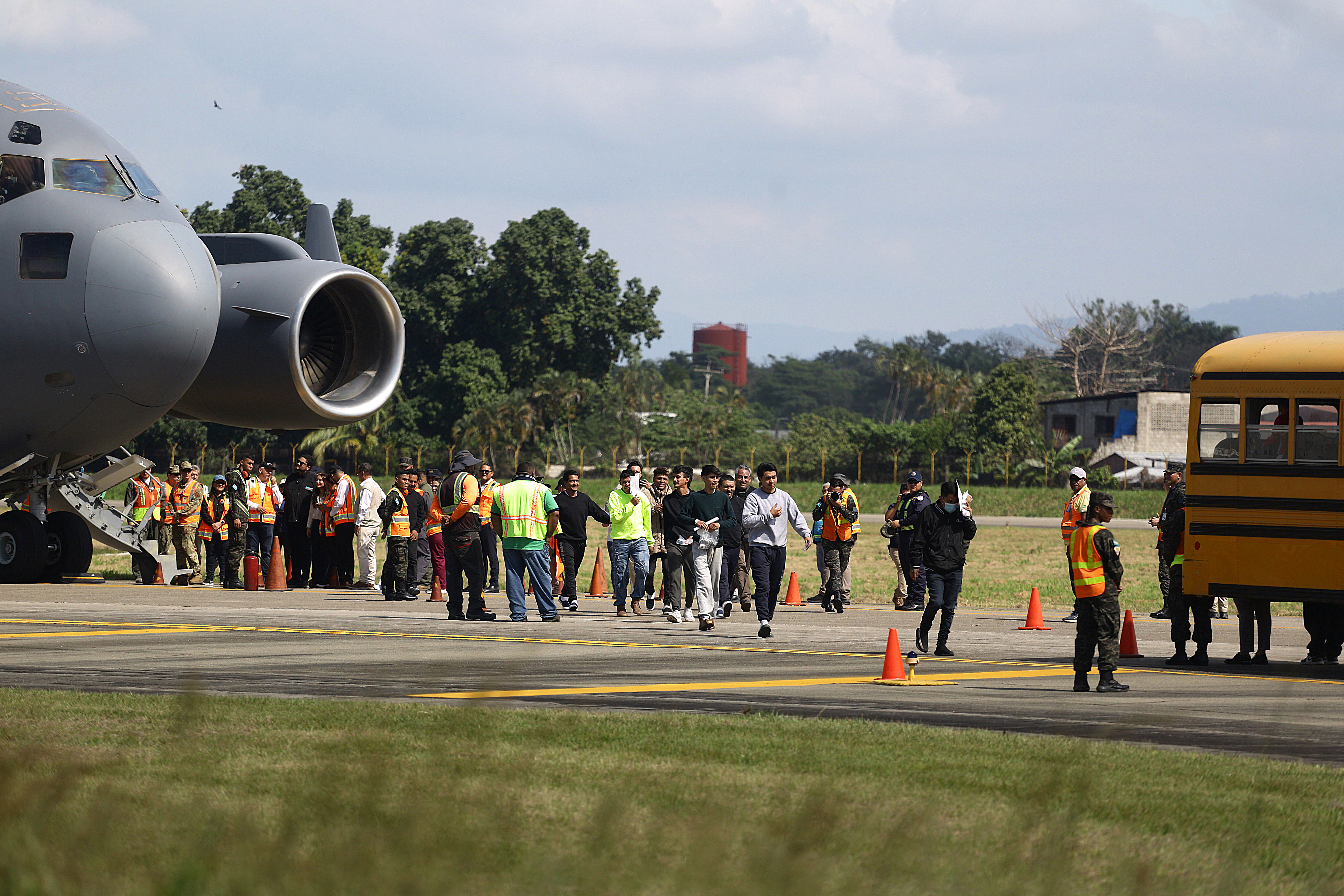 SAN PEDRO SULA, HONDURAS - JANUARY 31: Deported migrants by the US Government walk to the bus upon the flight arrival at Ramon Villeda Morales International Airport on January 31, 2025 in San Pedro Sula, Honduras. Honduras receives 126 migrants in two different flights as part of mass deportation plans by the Trump's administration. People were captured once they got into the US or during the raids conducted by the authorities. (Photo by Jorge Salvador Cabrera/Getty Images)