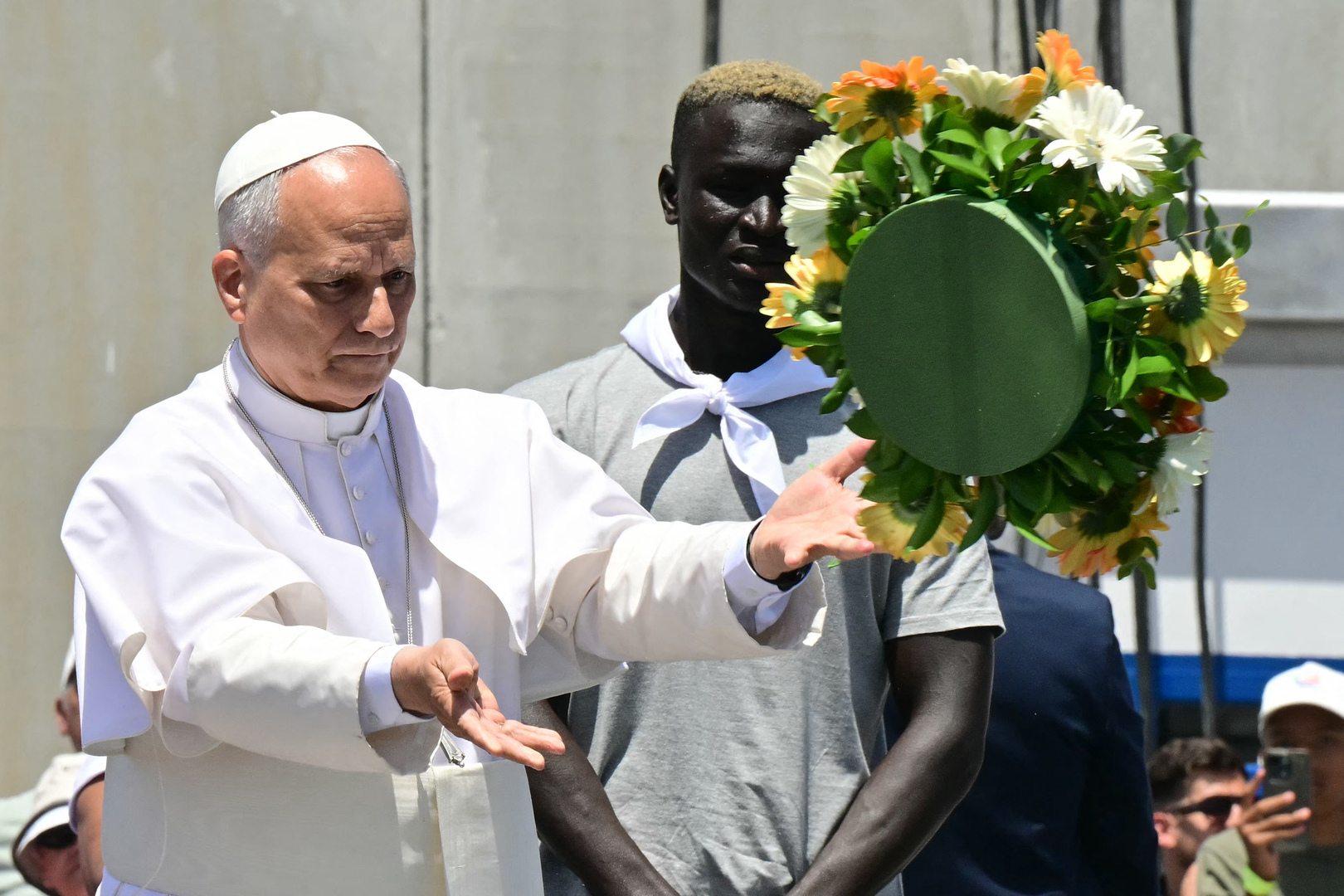 Pope Leo XIV throws a wreath to the sea to remember all the migrants who perished during their journey, at the Port of Arguineguin on the Canary Island of Gran Canaria, a place accustomed to the arrival of migrants, on June 11, 2026. {STEFANO RELLANDINI/AFP}