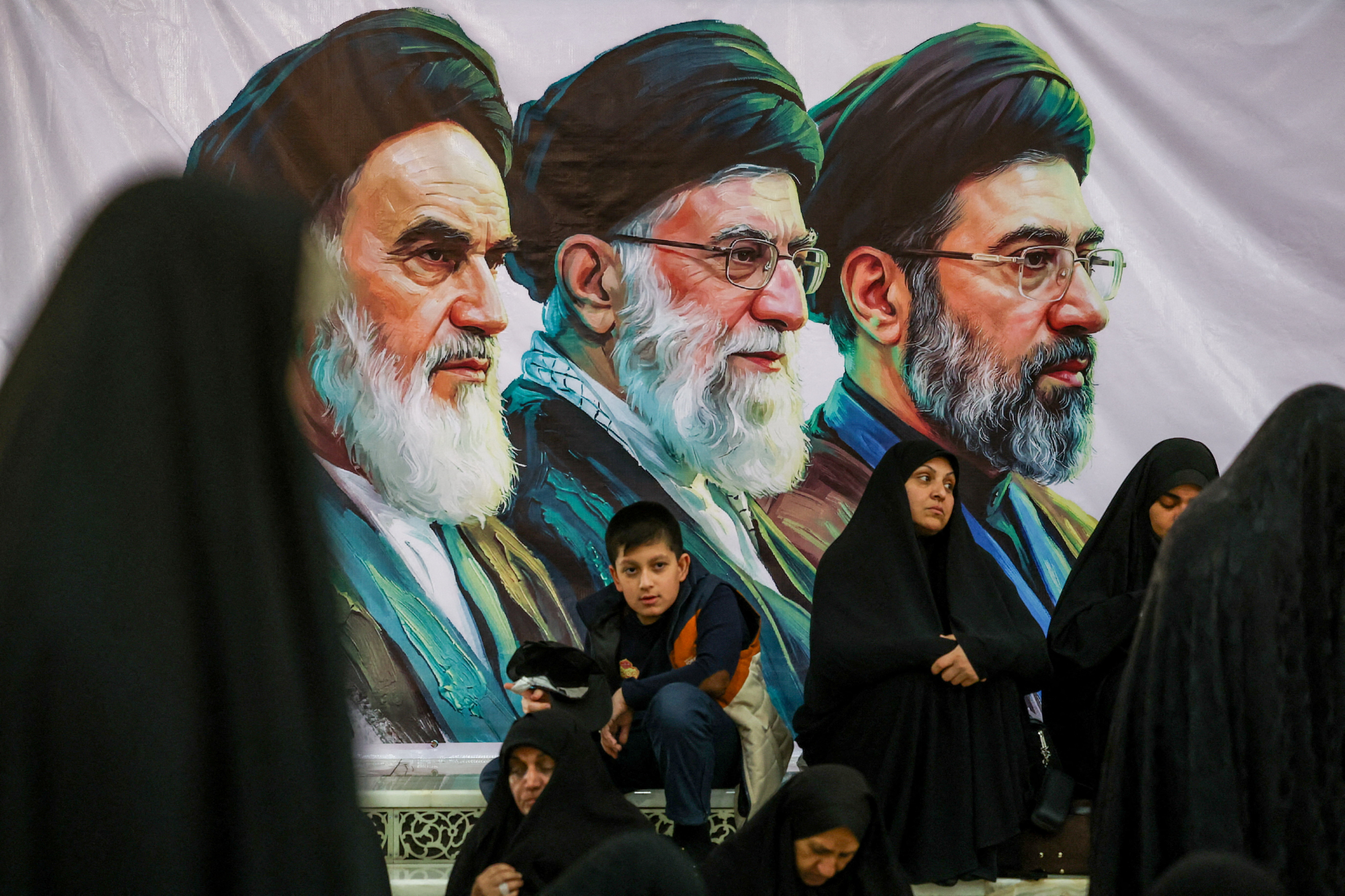 People gather near a banner with images of Iran's late leader of the Islamic Revolution Ayatollah Ruhollah Khomeini, Iran's late Supreme Leader Ayatollah Ali Khamenei and Iran's Supreme Leader Mojtaba Khamenei, on the day of a ceremony for the 37th anniversary of the death of Ayatollah Ruhollah Khomeini at Khomeini's shrine in southern Tehran, Iran June 4, 2026. Majid Asgaripour/WANA (West Asia News Agency) via REUTERS ATTENTION EDITORS - THIS PICTURE WAS PROVIDED BY A THIRD PARTY. ISRAEL OUT. NO COMMERCIAL OR EDITORIAL SALES IN ISRAEL. NO ACCESS FOR ISRAELI MEDIA. NO USE BBC PERSIAN. NO USE VOA PERSIAN. NO USE MANOTO. NO USE IRAN INTERNATIONAL. NO USE RADIO FARDA. DIGITAL: NO USE BBC PERSIAN. NO USE VOA PERSIAN. NO USE MANOTO. NO USE IRAN INTERNATIONAL. NO USE RADIO FARDA. TPX IMAGES OF THE DAY