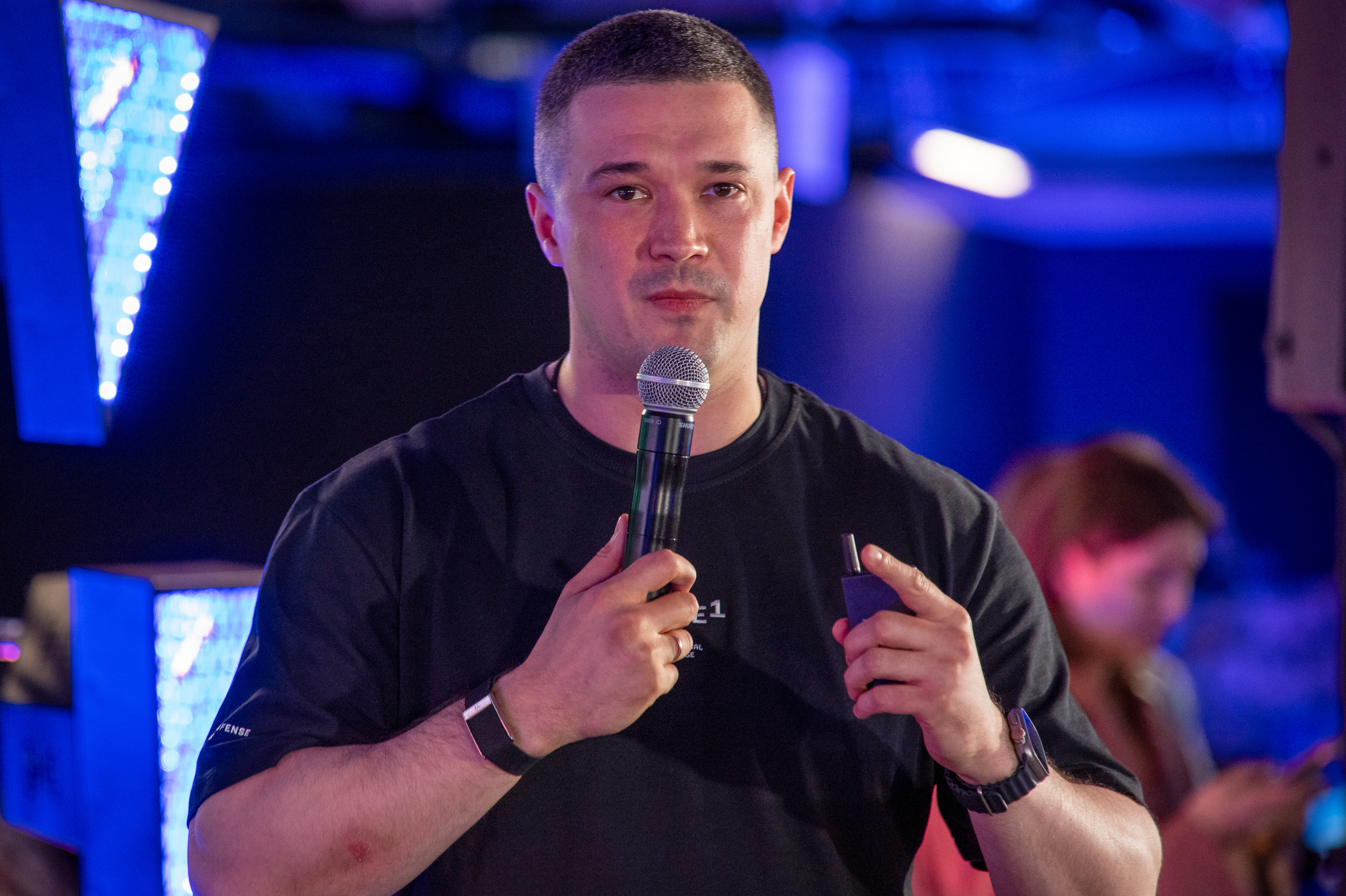 A man stands with a microphone