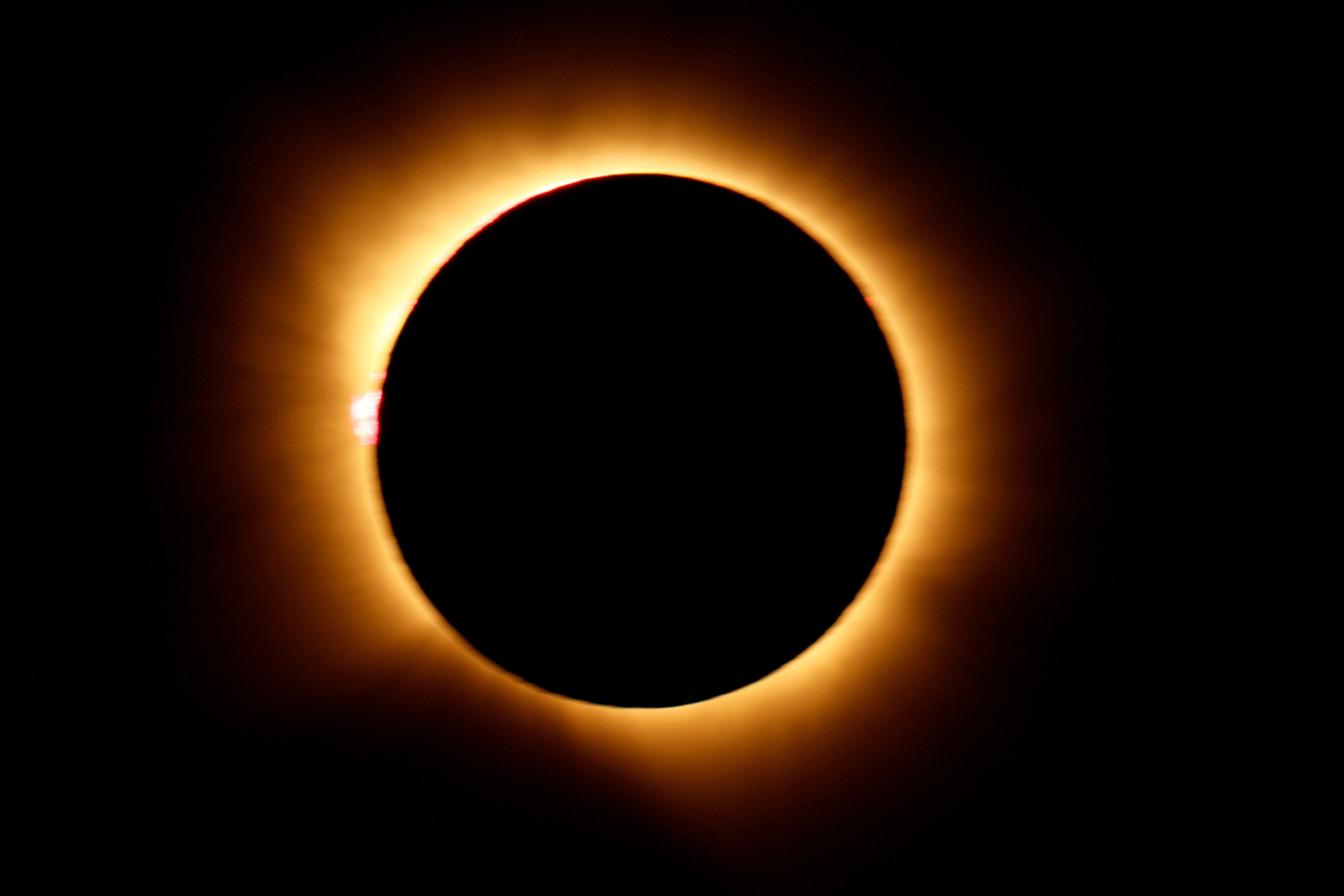 The moon completely covering the sun during a total solar eclipse.