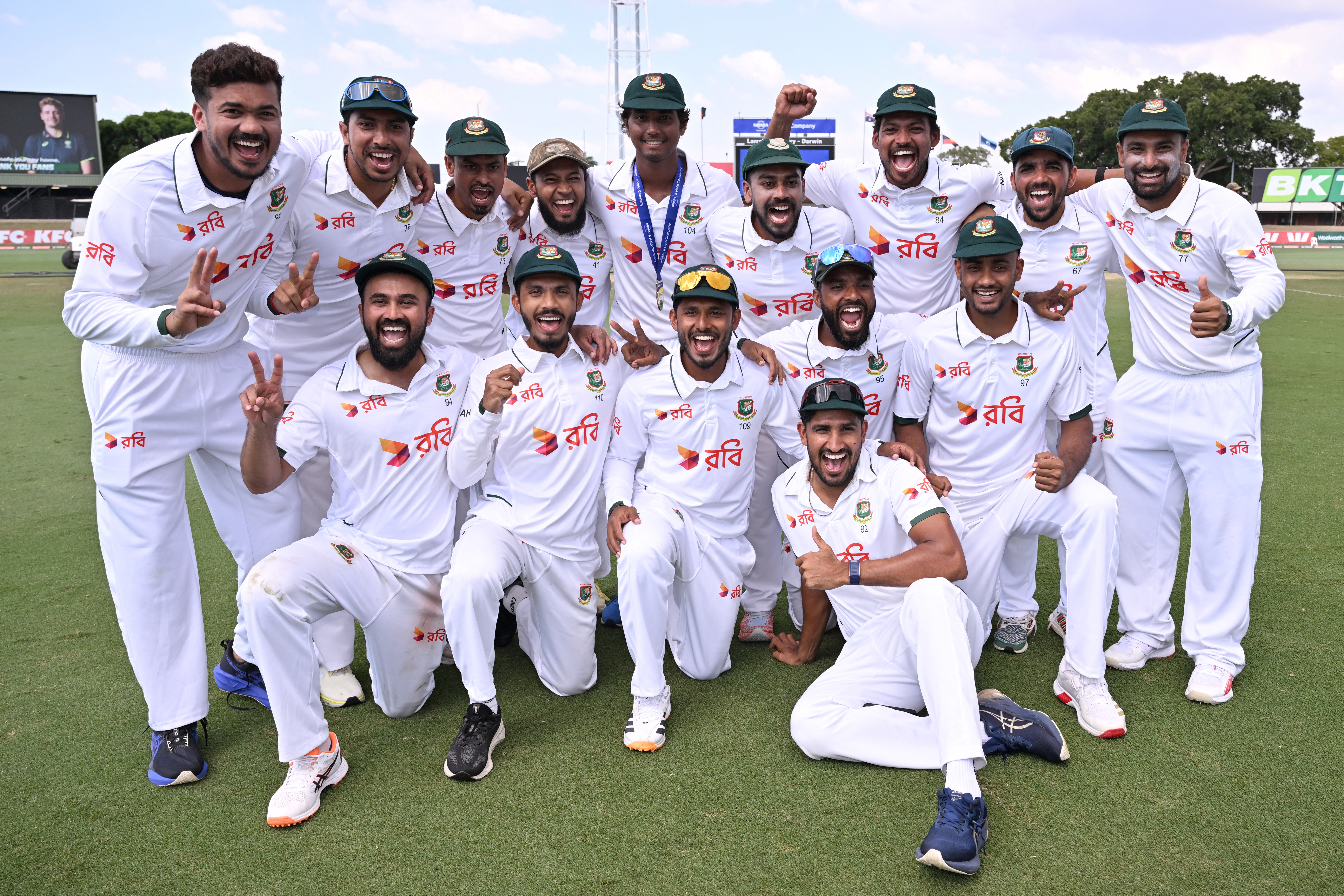 Bangladesh players pose for a photo after their team's victory on the fourth day of the first cricket Test match against Australia