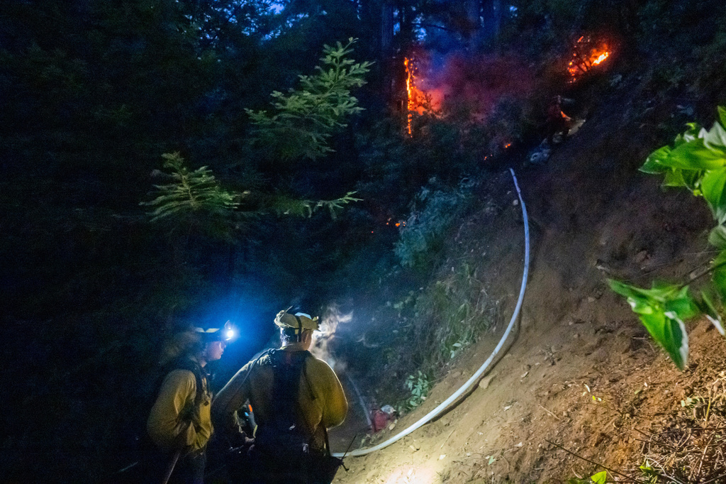 firefighters face flames during the night