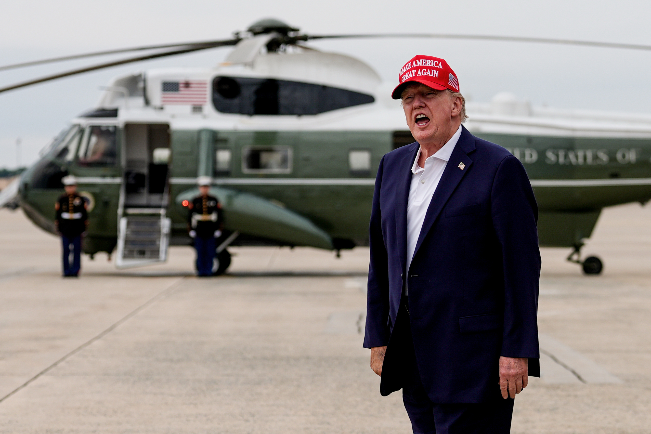 President Donald Trump yells to reporters after disembarking Air Force One