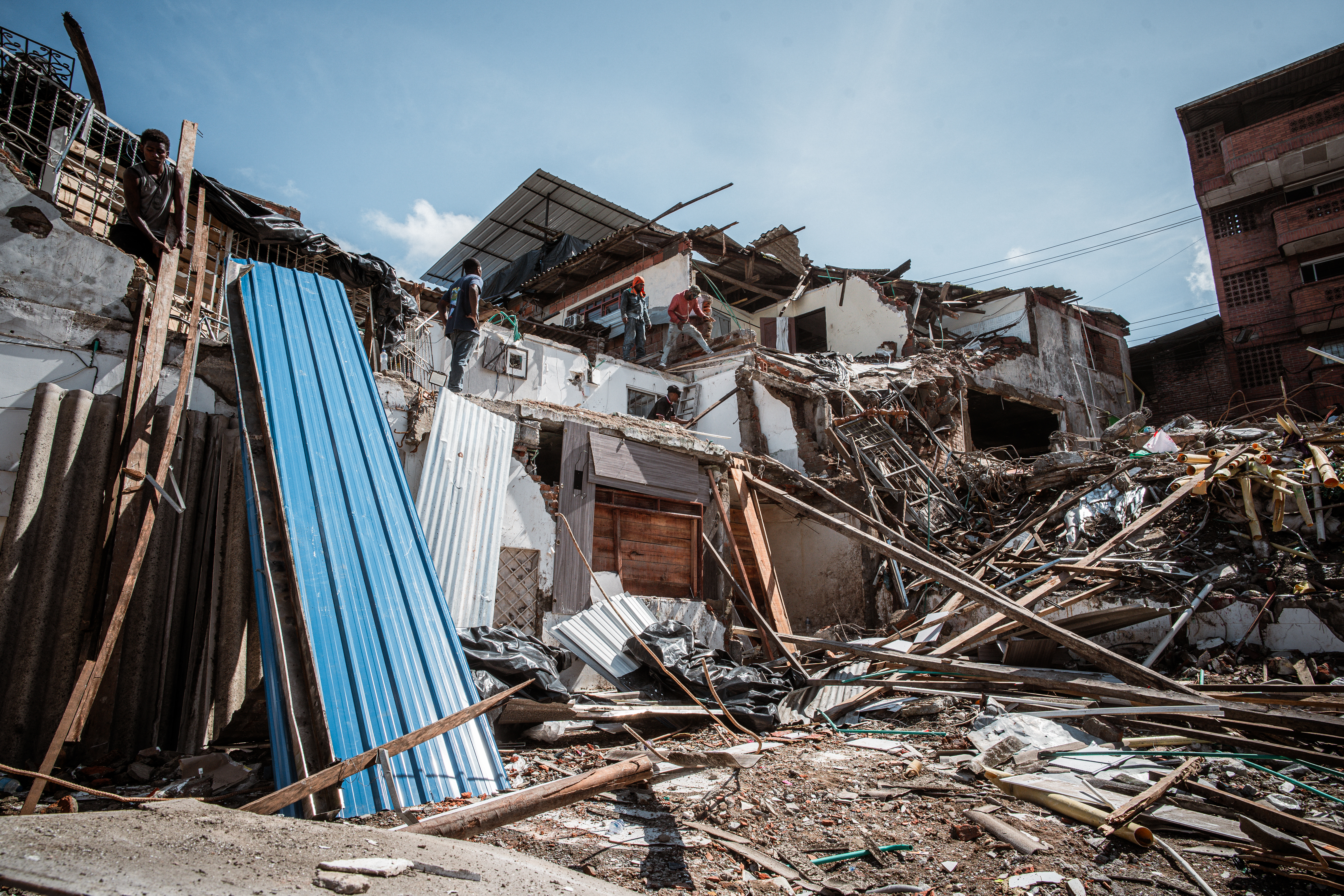 A row of houses that have been partially crushed by a falling building in Buenaventura. [Euan Wallace / Al Jazeera]