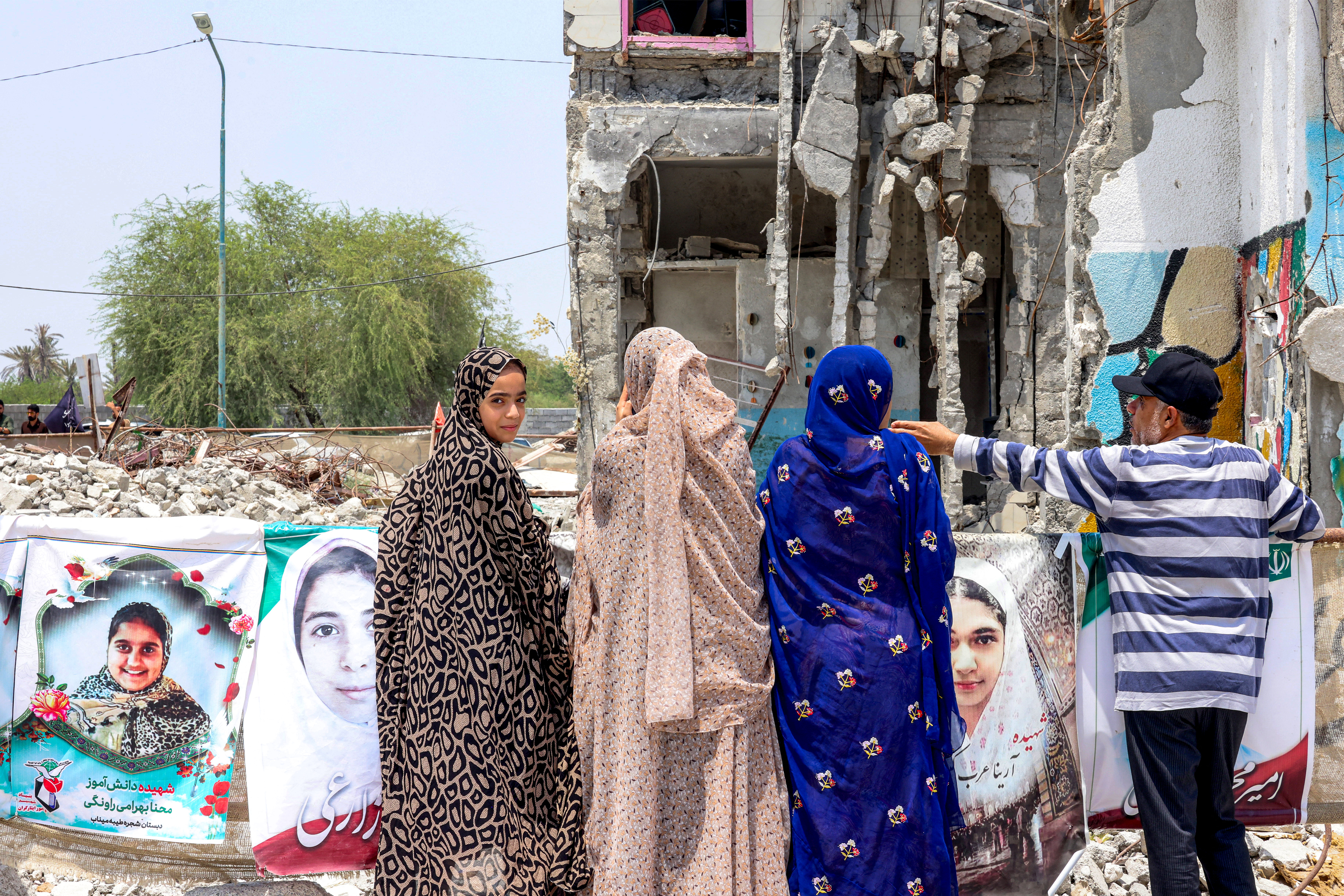 People stand near the building of the destroyed Shajareh Tayyebeh primary school in Minab in Iran’s Hormozgan province on August 10, 2026.