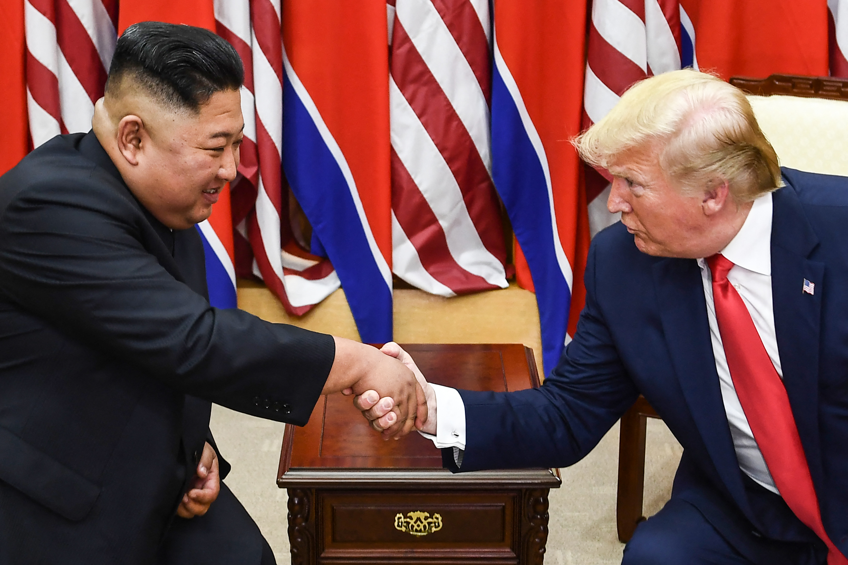 (FILES) North Korea's leader Kim Jong Un (L) and US President Donald Trump shake hands during a meeting on the south side of the Military Demarcation Line that divides North and South Korea, in the Joint Security Area (JSA) of Panmunjom in the Demilitarized zone (DMZ) on June 30, 2019.