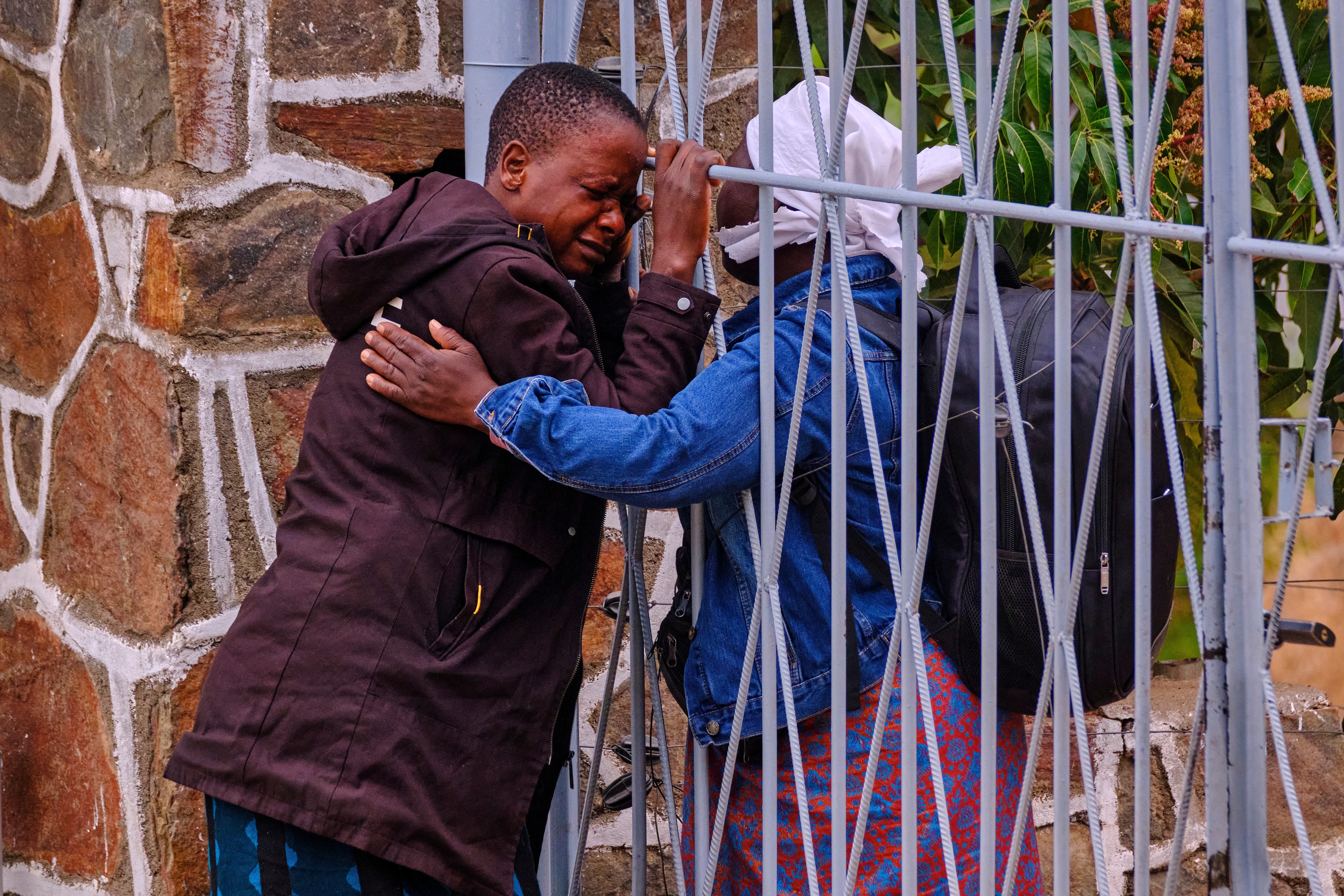 A woman is embraced by a colleague after losing her 9-year-old daughter and 6-year-old nephew in a ferry capsizing on Lake Kariba, in Kariba, Zimbabwe