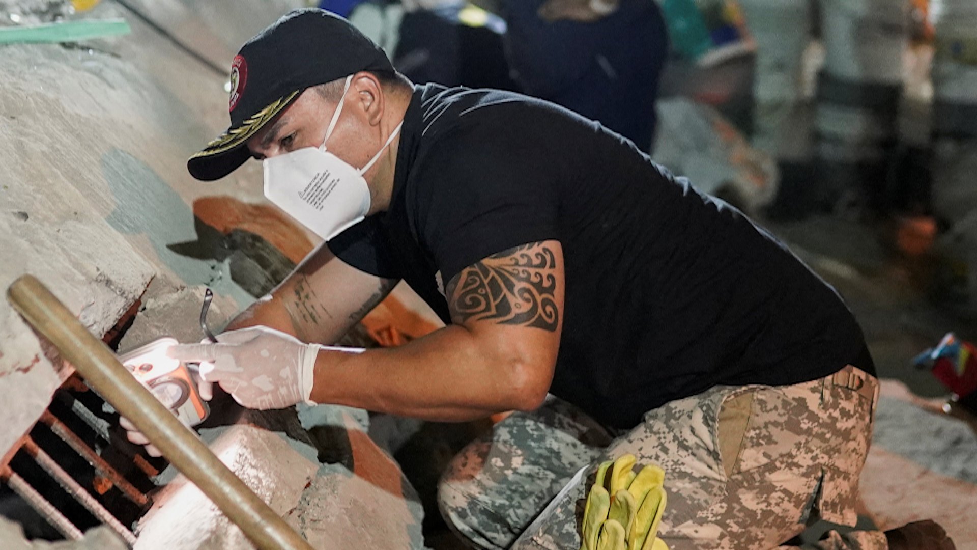 A rescuer shines his mobile phone's torchlight through the rubble, as search-and-rescue operations continue at the Torres de Limonar building in the aftermath of an earthquake, in Cali, Colombia, August 11, 2026. [REUTERS/Sergio Acero]