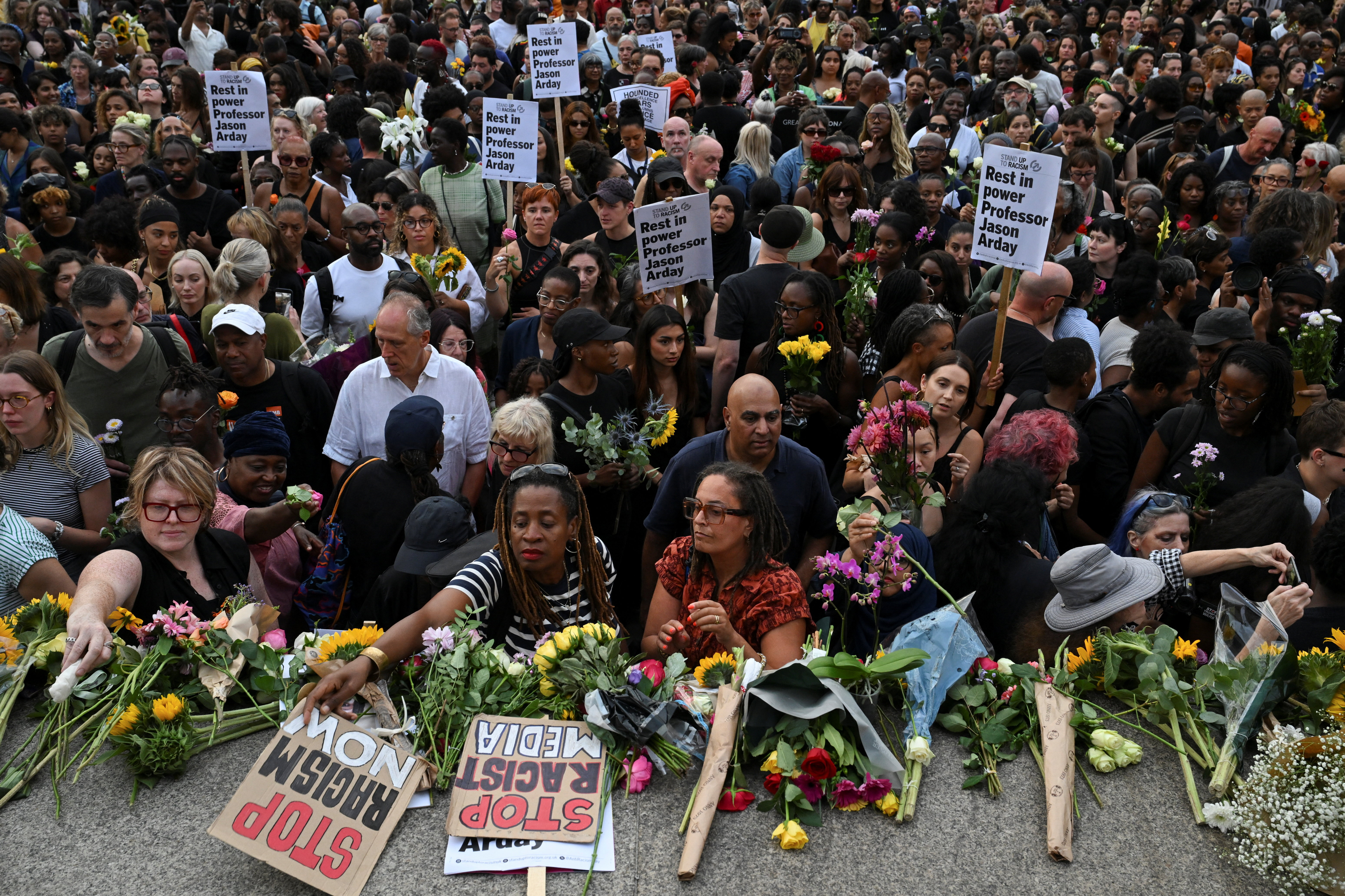 People lay flowers down at the end of a vigil by Stand Up To Racism to remember former Cambridge professor Jason Arday, who died aged 41 on Friday after resigning amid plagirism allegations he denied, at Trafalgar Square in London, Britain, August 17, 2026. REUTERS/Chris J. Ratcliffe