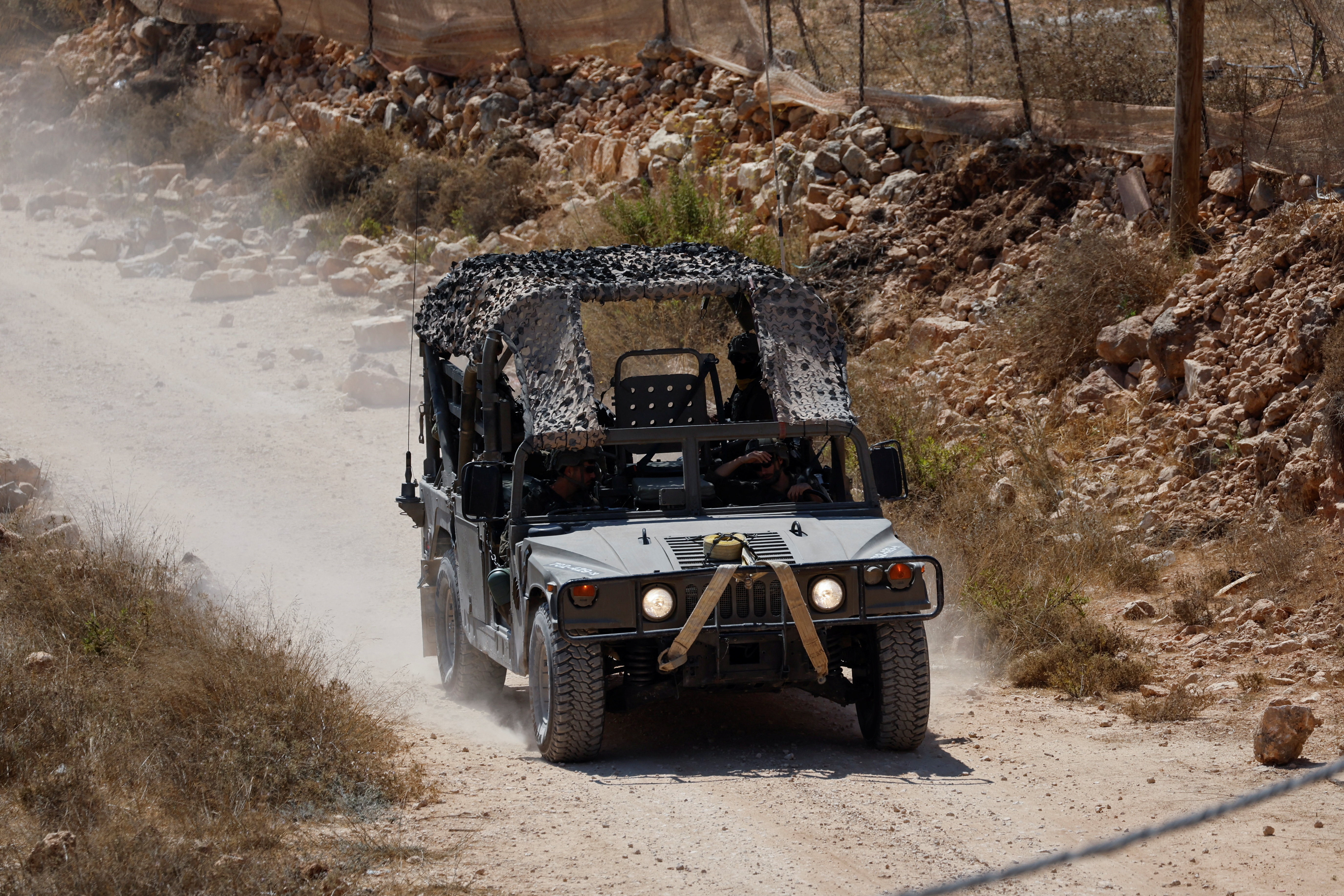 Israeli military vehicle drives near the home of Palestinian-American Loui Ridi, which has been encircled by militant Israeli settlers for more than a week, after Ridi gained access to it, in Qusra, Israeli-occupied West Bank, August 19, 2026. REUTERS/Mussa Qawasma