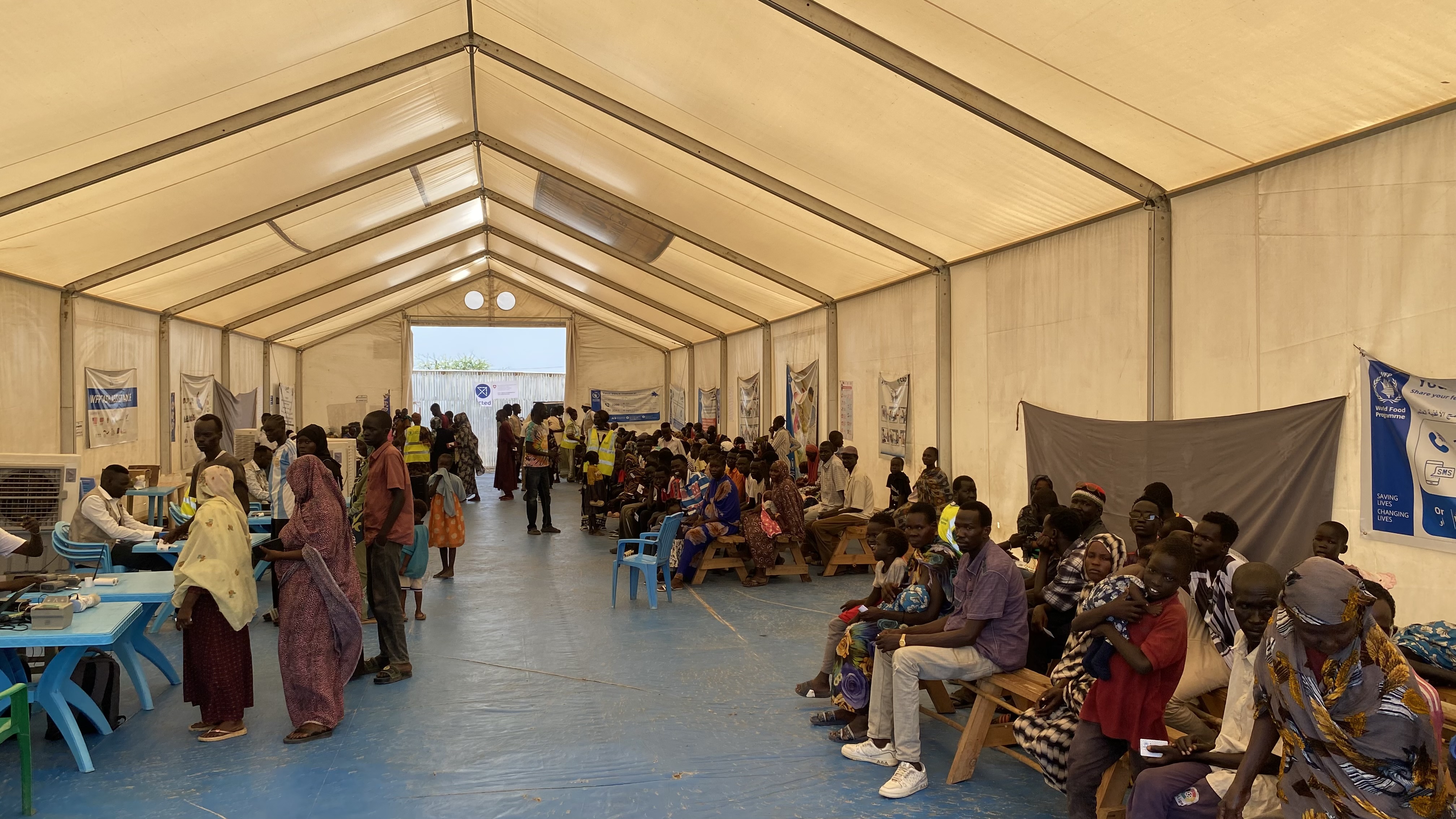 Families gather inside a WFP registration centre in Renk, South Sudan, after fleeing the war in Sudan. Funding shortages threaten food and nutrition assistance for hundreds of thousands of refugees and asylum seekers [Maura Ajak/Al Jazeera]