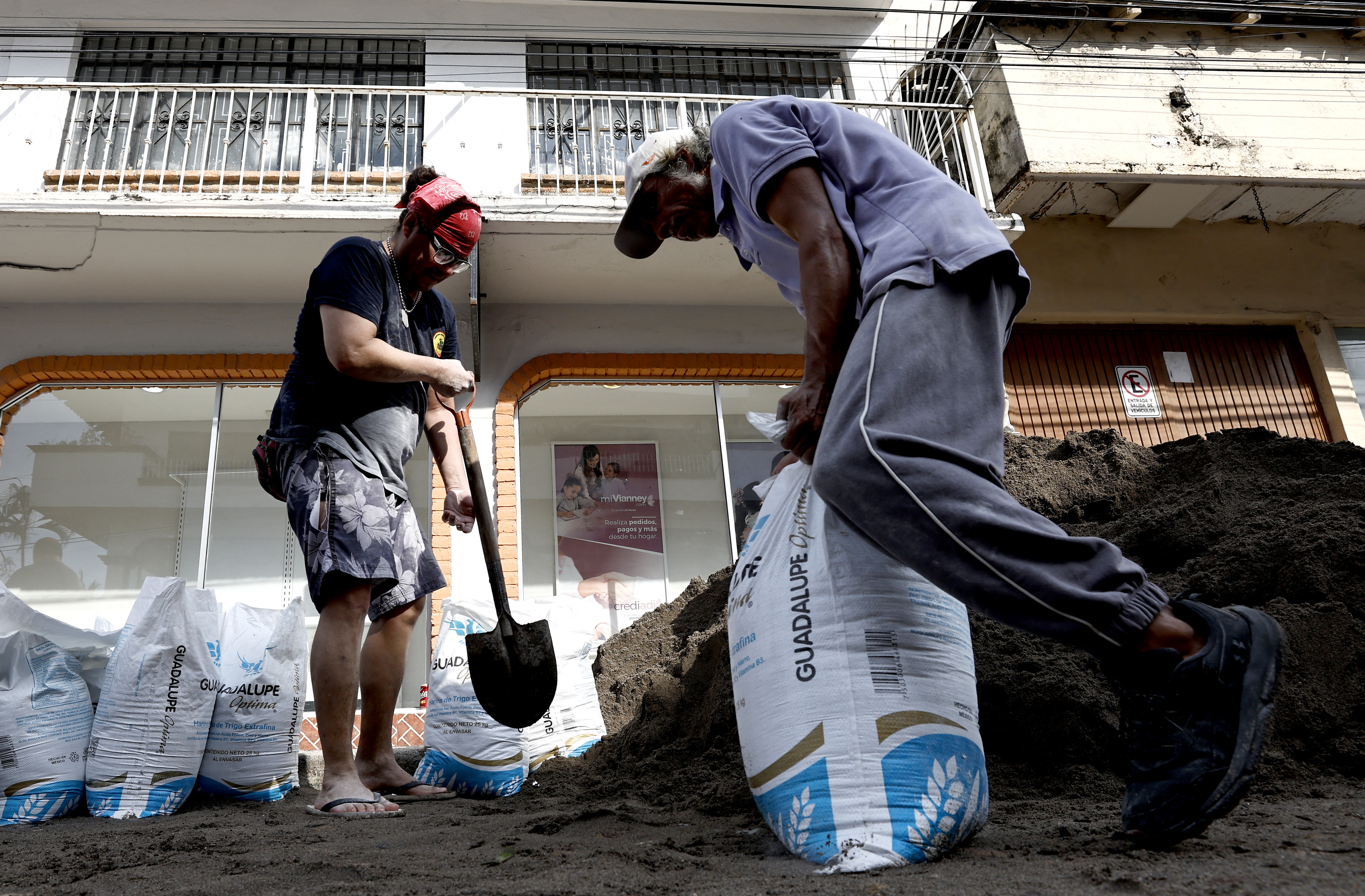 A man fills a sandbag to build a barricade to protect his business from the potential impact of Hurricane Simon in Puerto Vallarta, Jalisco state, Mexico, on October 9, 2026. Hurricane Simon is forecast to rapidly strengthen before striking Mexico's Pacific coast, the US National Hurricane Center said on october 9. (Photo by ULISES RUIZ / AFP)