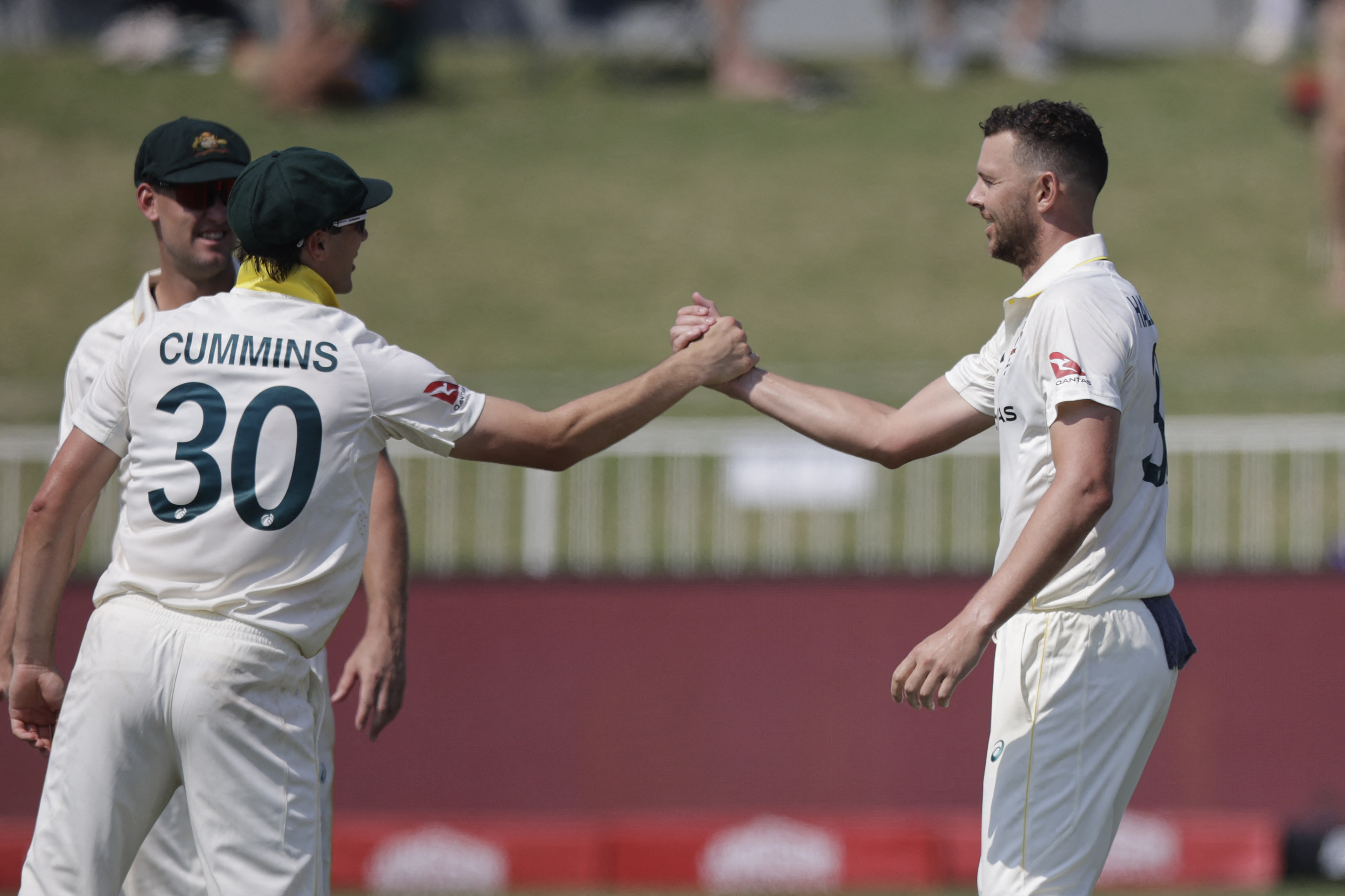 Australia’s Josh Hazlewood (R) celebrates with Australia’s Pat Cummins (L) after the dismissal of South Africa’s Marco Jansen on day three of the first Test match between South Africa and Australia at the Kingsmead stadium in Durban on October 11, 2026. (Photo by Marco Longari / AFP)