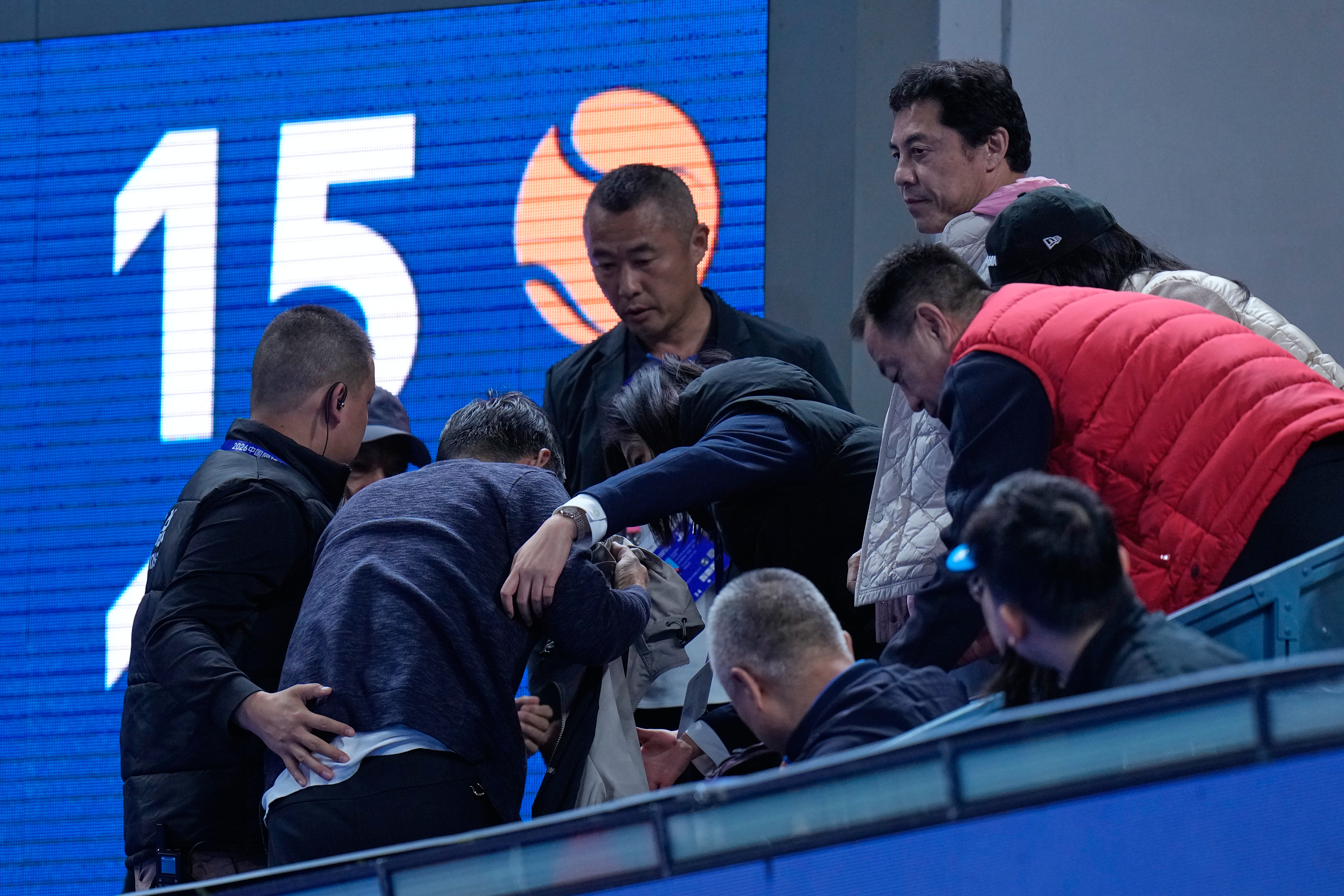 Officials assist a man injured by a ball hit into the stands by Daniil Medvedev, of Russia, during the men's single semi-final match against Novak Djokovic