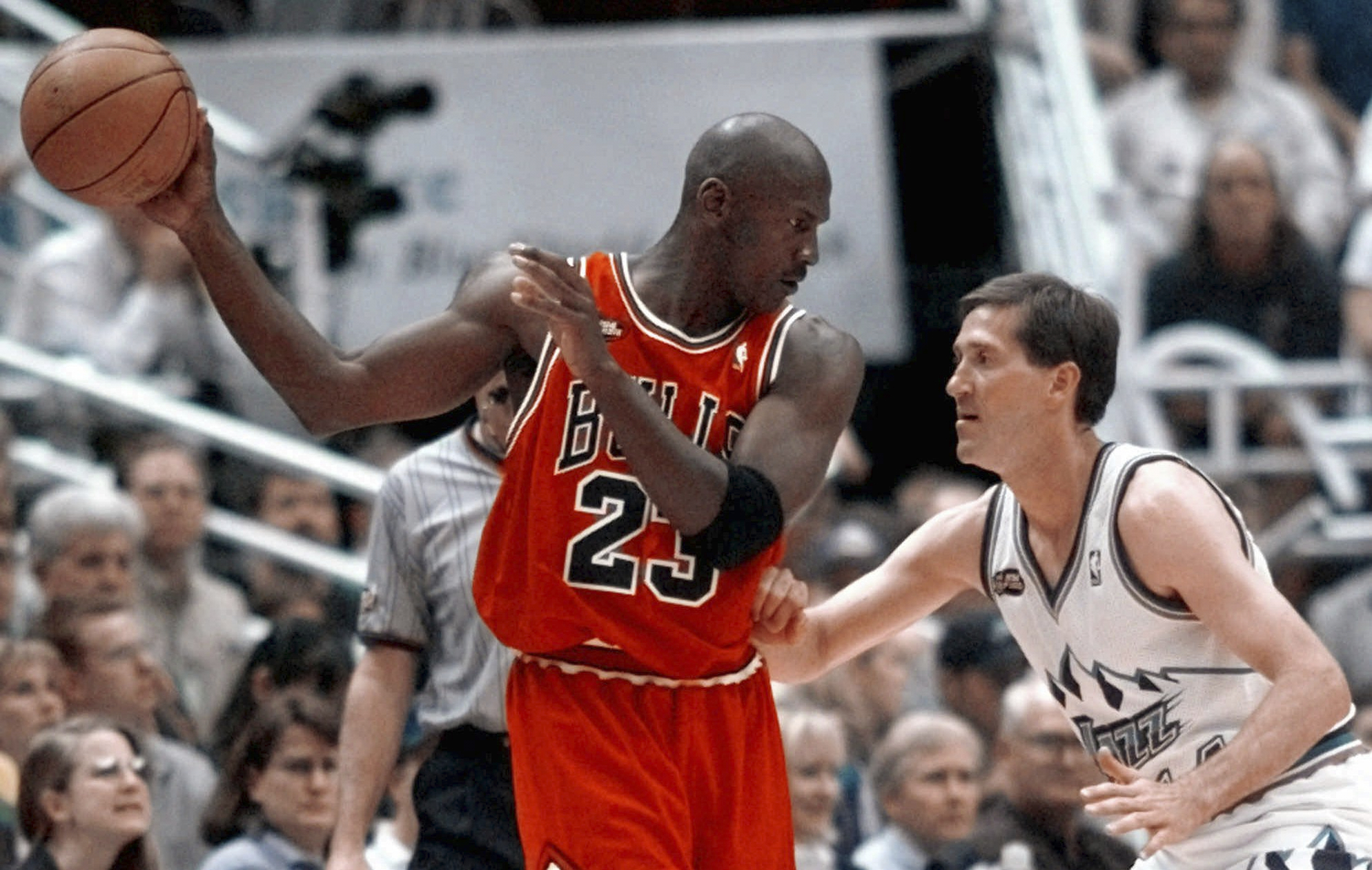 Chicago Bulls' Michael Jordan pulls the ball out of reach of Utah Jazz guard Jeff Hornacek during a game.