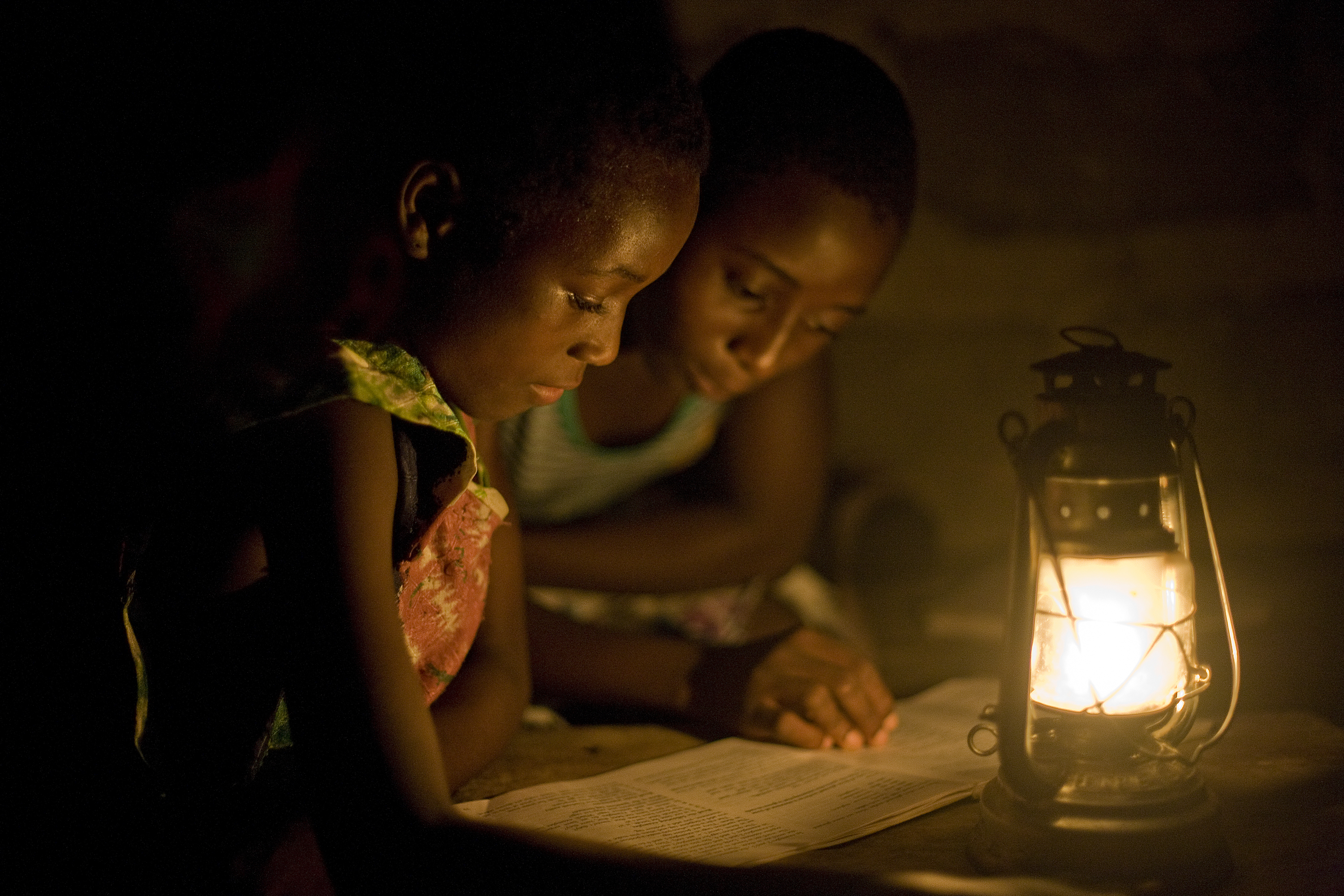 NEAR ACCRA, GHANA - 2009/02/19: Rural Ghanian students study with the help of a kerosene lantern in the evening. Many villages in rural Ghana lack electrical infrastructure, making it difficult for students to study in the evenings.
