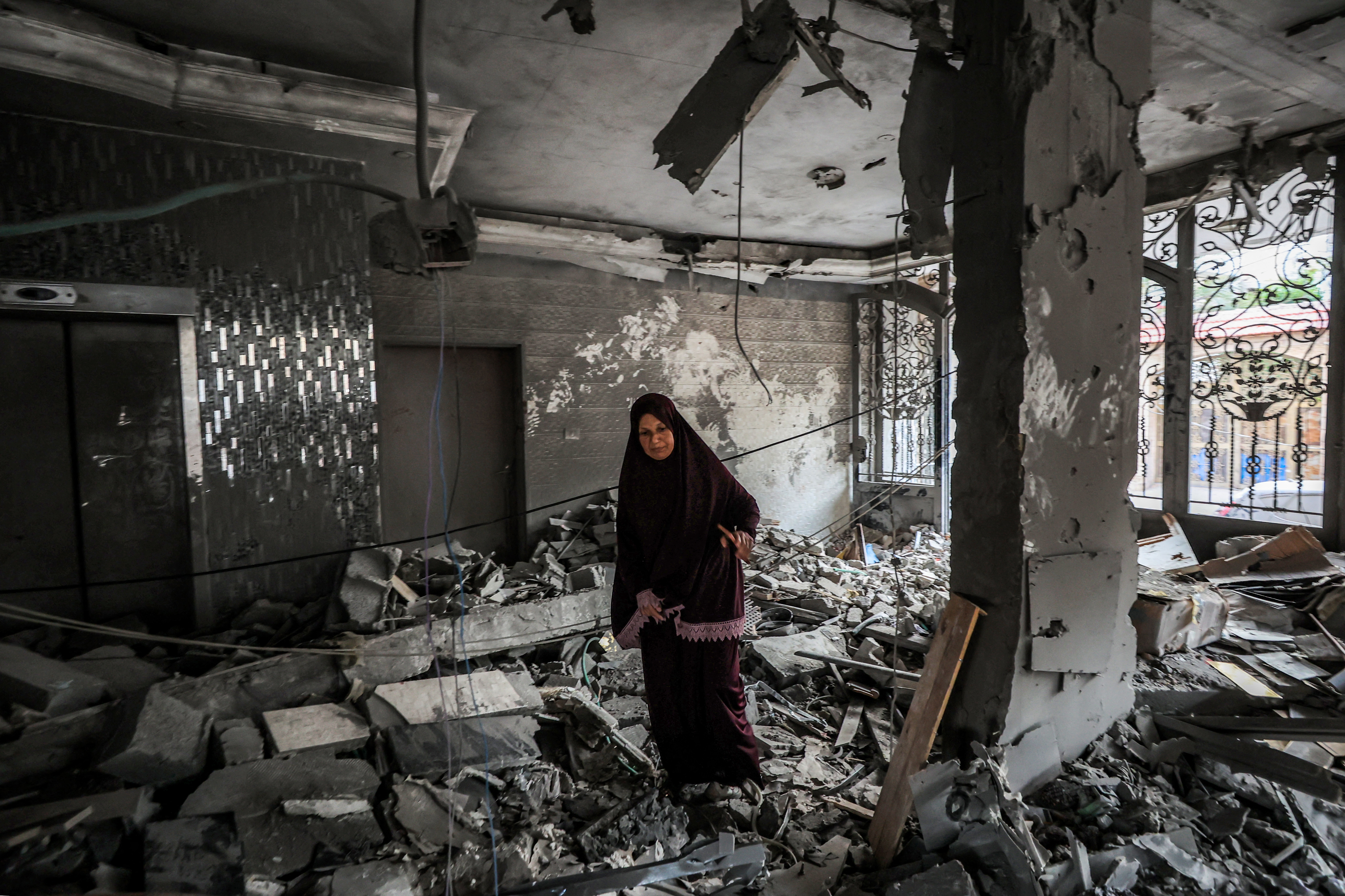 A woman inspects debris in a heavily-damaged building following an Israeli strike on a residential apartment in the Rimal neighbourhood of Gaza City early on October 3, 2026.