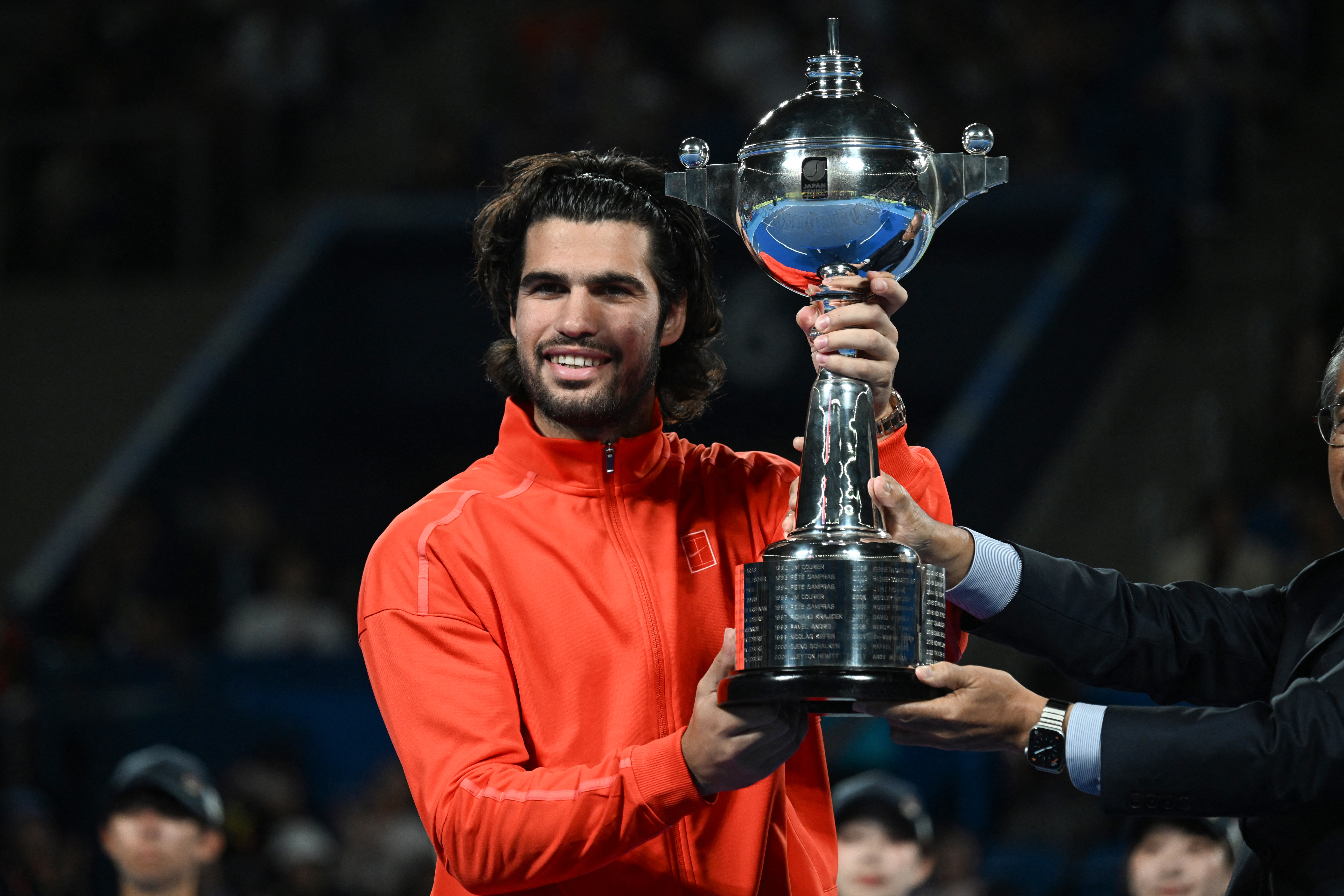Spain's Carlos Alcaraz holds the trophy as he celebrates beating Czech Republic's Jiri Lehecka in the men's singles final during the Japan Open tennis tournament at the Ariake Tennis Forest Park in Tokyo on October 6, 2026. (Photo by Rie KIKUCHI / AFP)