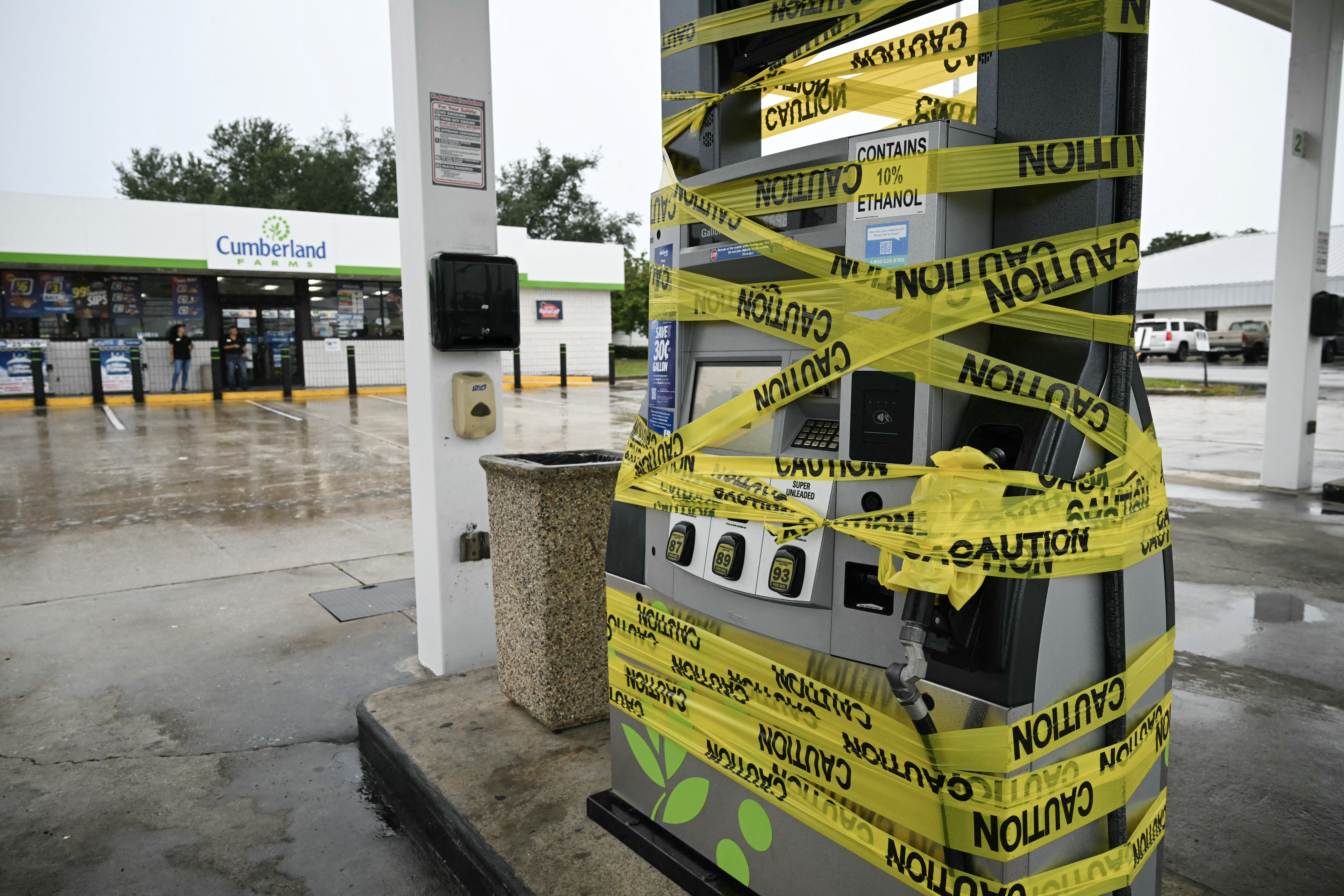 Workers cordon off a petrol pump with yellow tape at a gas station in Navarre, Florida, on October 9, 2026, as Hurricane Isaias moves north toward the Florida Panhandle. [AFP]