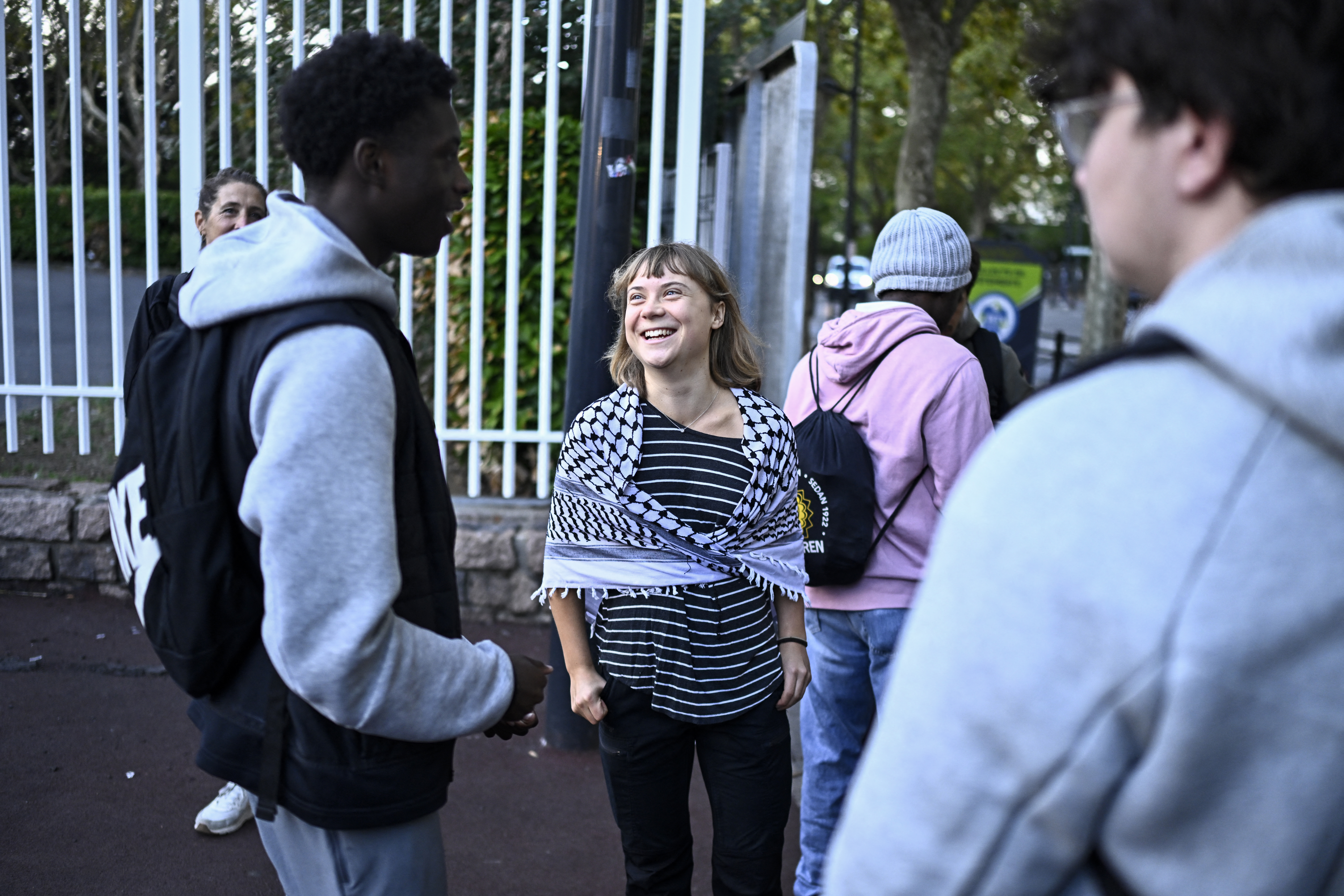 Swedish activist Greta Thunberg speaks with students as she wears a keffiyeh (Palestinian scarf).