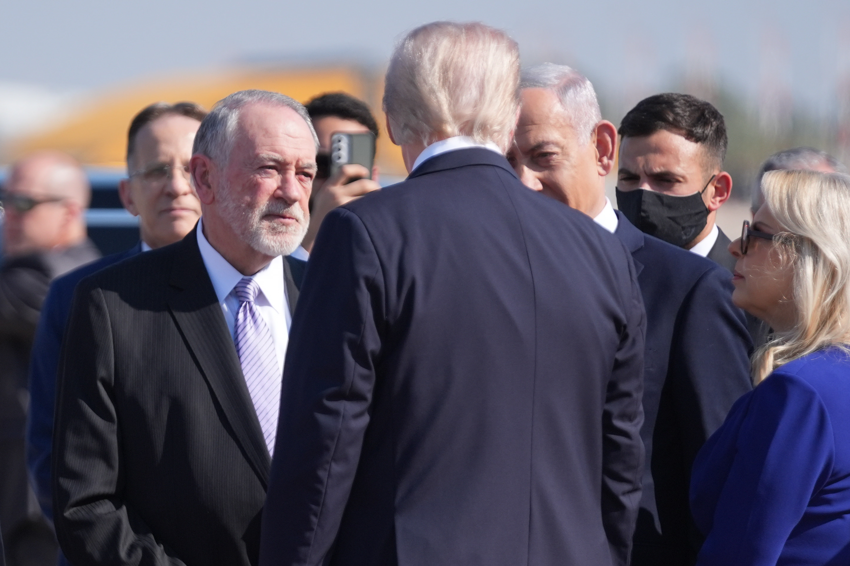 President Donald Trump talks with U.S. ambassador to Israel Mike Huckabee and Israel's Prime Minister Benjamin Netanyahu as he arrives at Ben Gurion International Airport, Monday, Oct. 13, 2025, near Tel Aviv. (AP Photo/Evan Vucci)
