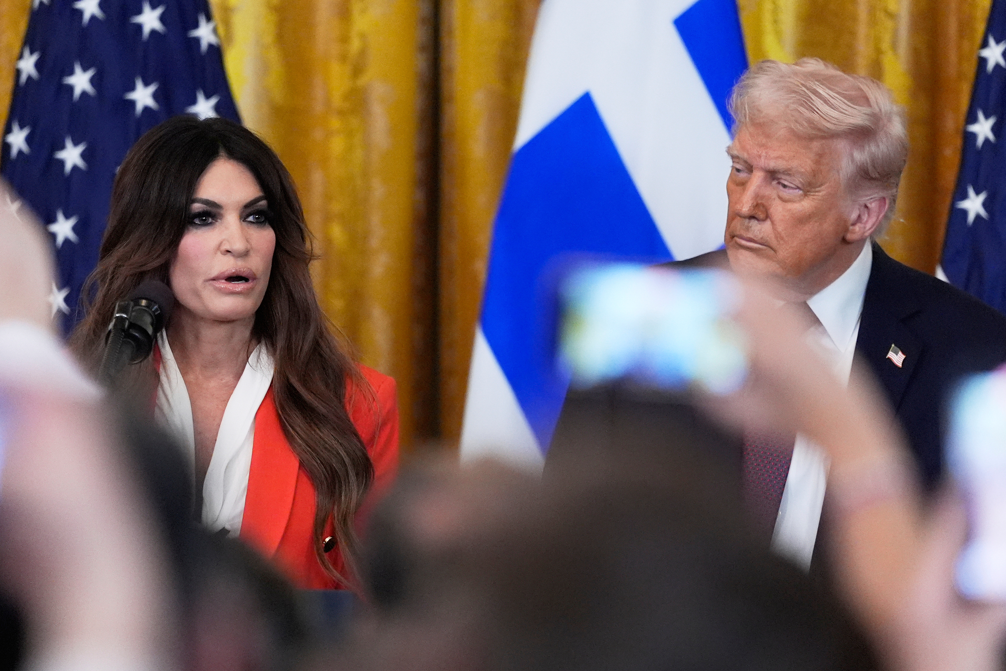 FILE - Kimberly Guilfoyle speaks as President Donald Trump listens at a reception celebrating Greek Independence Day in the East Room of the White House, March 24, 2025, in Washington. (AP Photo/Mark Schiefelbein, File)