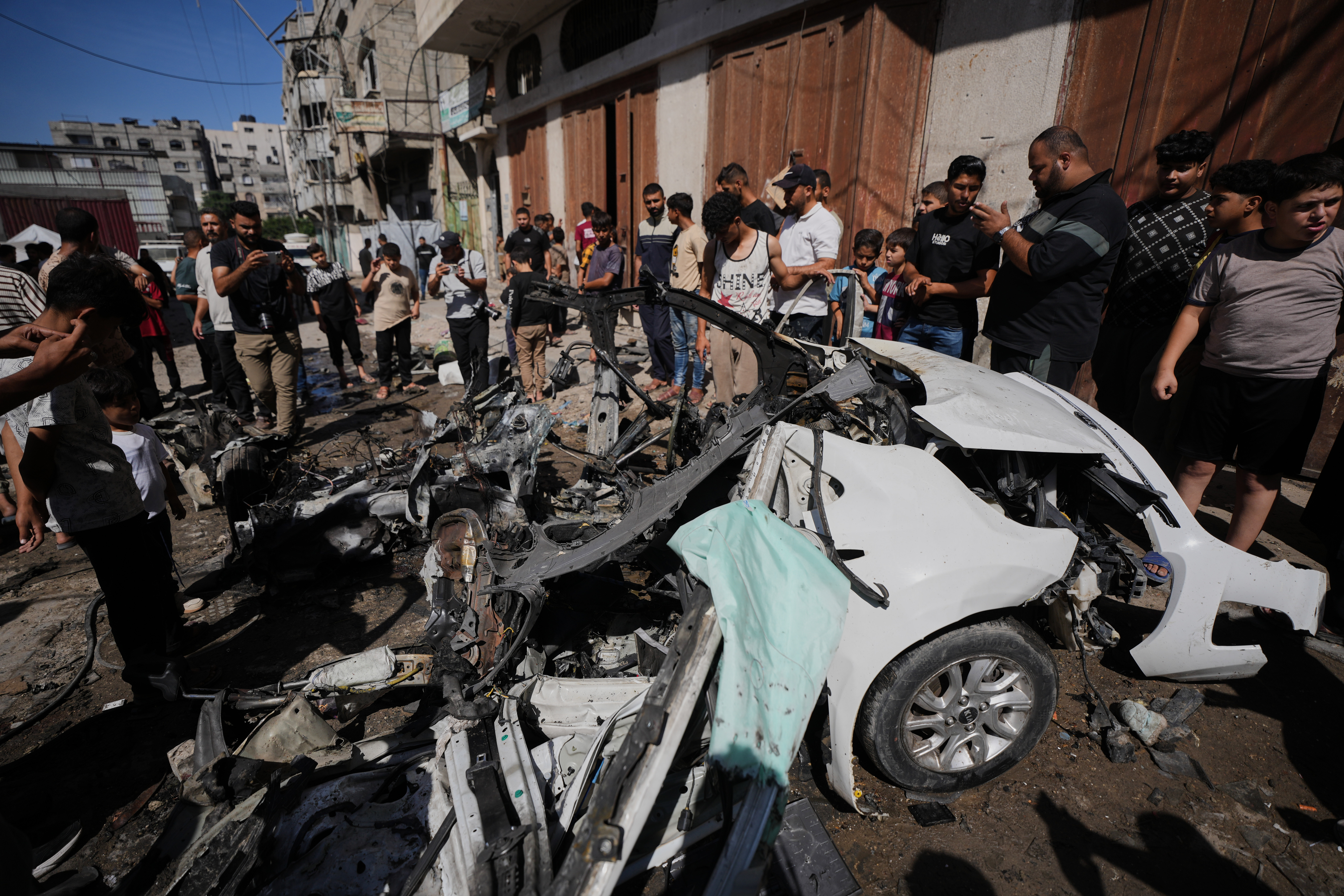Palestinians inspect the wreckage of a car after it was hit by an Israeli strike in Gaza City, Tuesday, Oct. 13, 2026. (AP Photo/Jehad Alshrafi)
