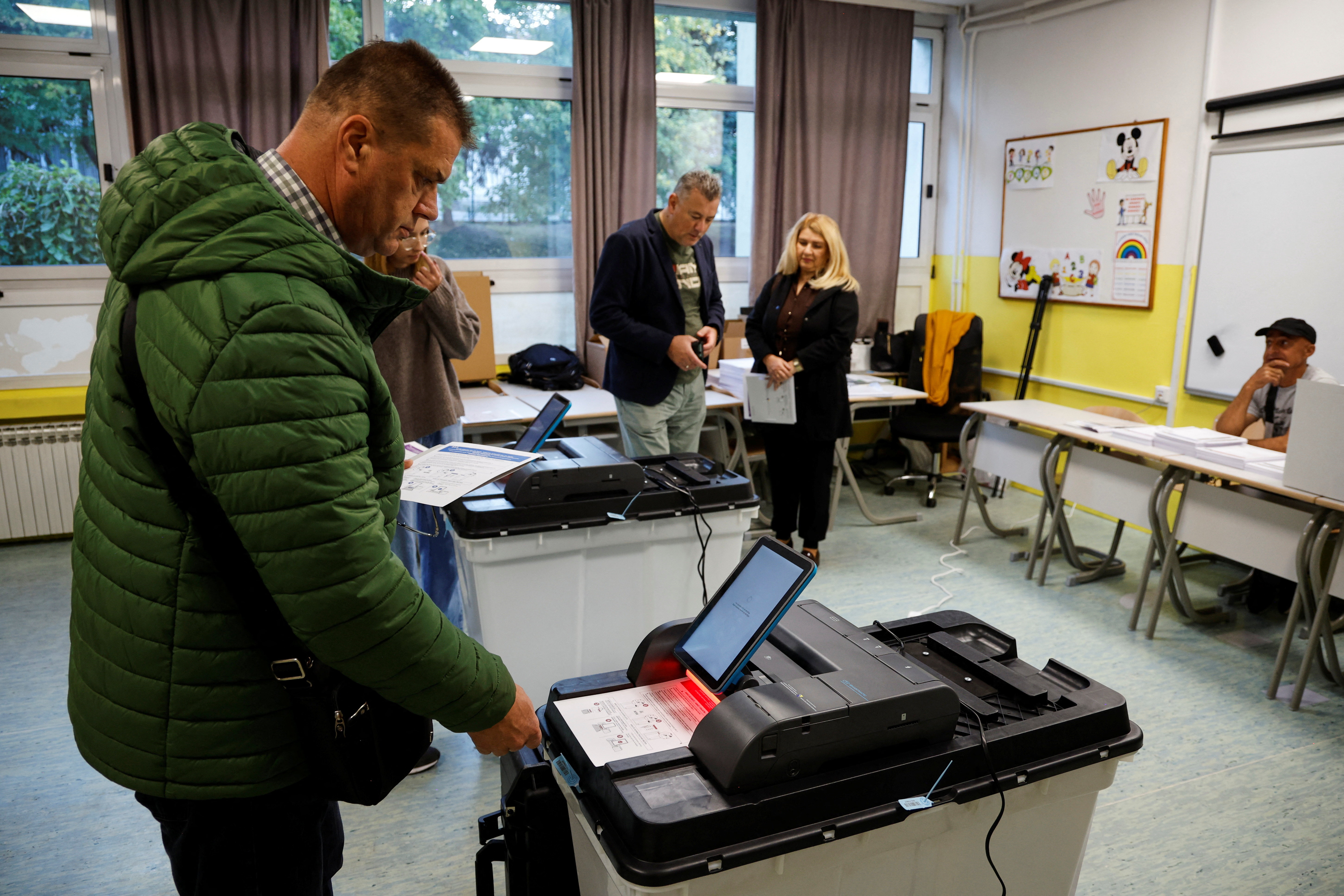 A voter scans his ballot at a polling station during Bosnia and Herzegovina's general election in Sarajevo