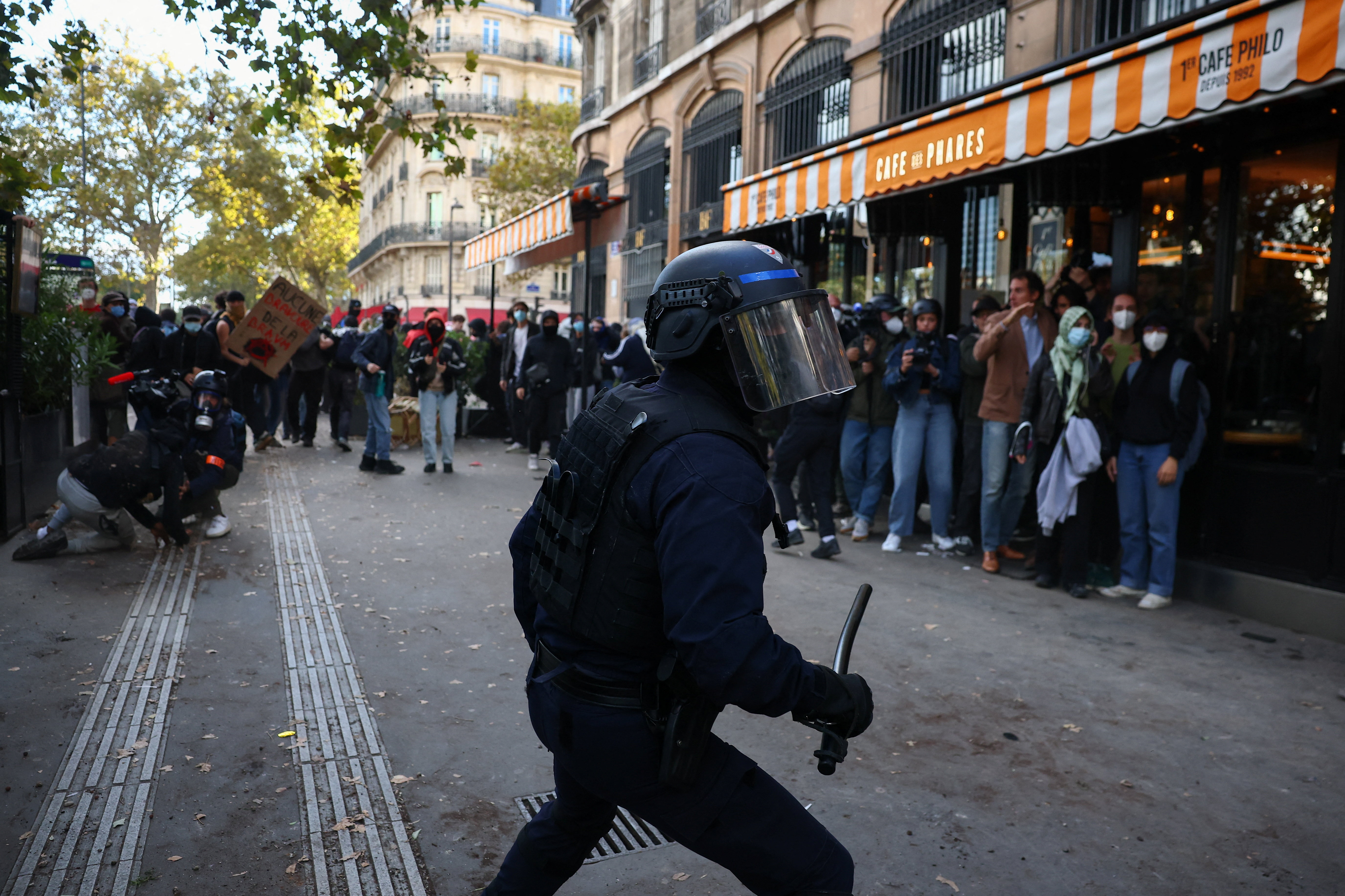 A police officer in riot gear holds a truncheon amid clashes with demonstrators during nationwide protests in Paris, France, October 8, 2026, to demand better school conditions. REUTERS/Pedro Nunes