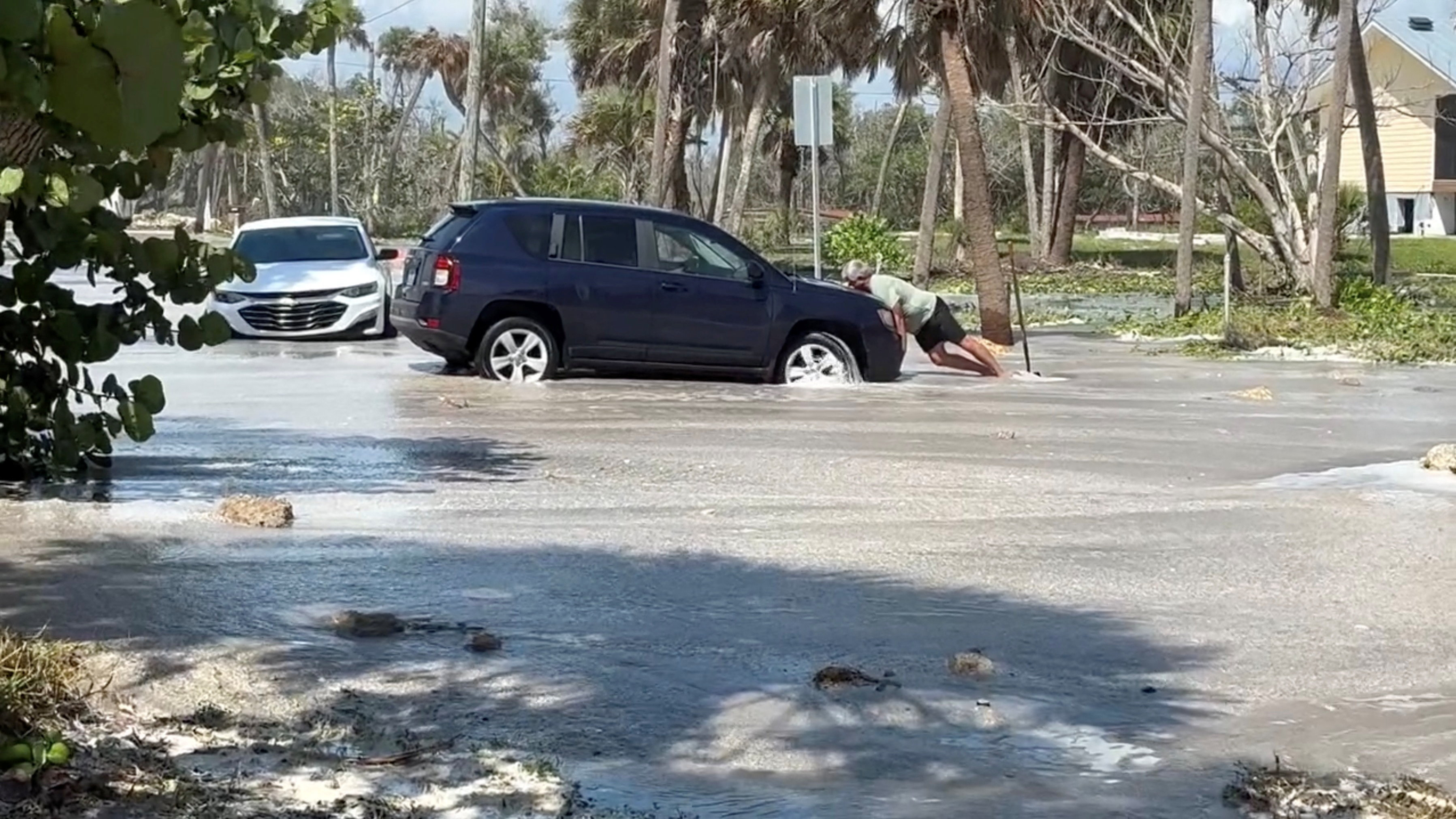 A man tries to push a car as waves wash over the road ahead of the arrival of Hurricane Isaias, in Englewood, Florida, US, October 9, 2026. Englewood Area Fire Control District via Facebook/Handout via REUTERS THIS IMAGE HAS BEEN SUPPLIED BY A THIRD PARTY. NO RESALES. NO ARCHIVES. MANDATORY CREDIT. Verification lines : Buildings, electricity poles, road signs, road layout and trees matched file and satellite images in the area. Date verified by government reports of Manasota Key Road in Englewood, Florida was closed due to waves washing over road. The US National Hurricane Center said Hurricane Isaias made landfall in western Florida panhandle, warning of danger from storm surges and floods.