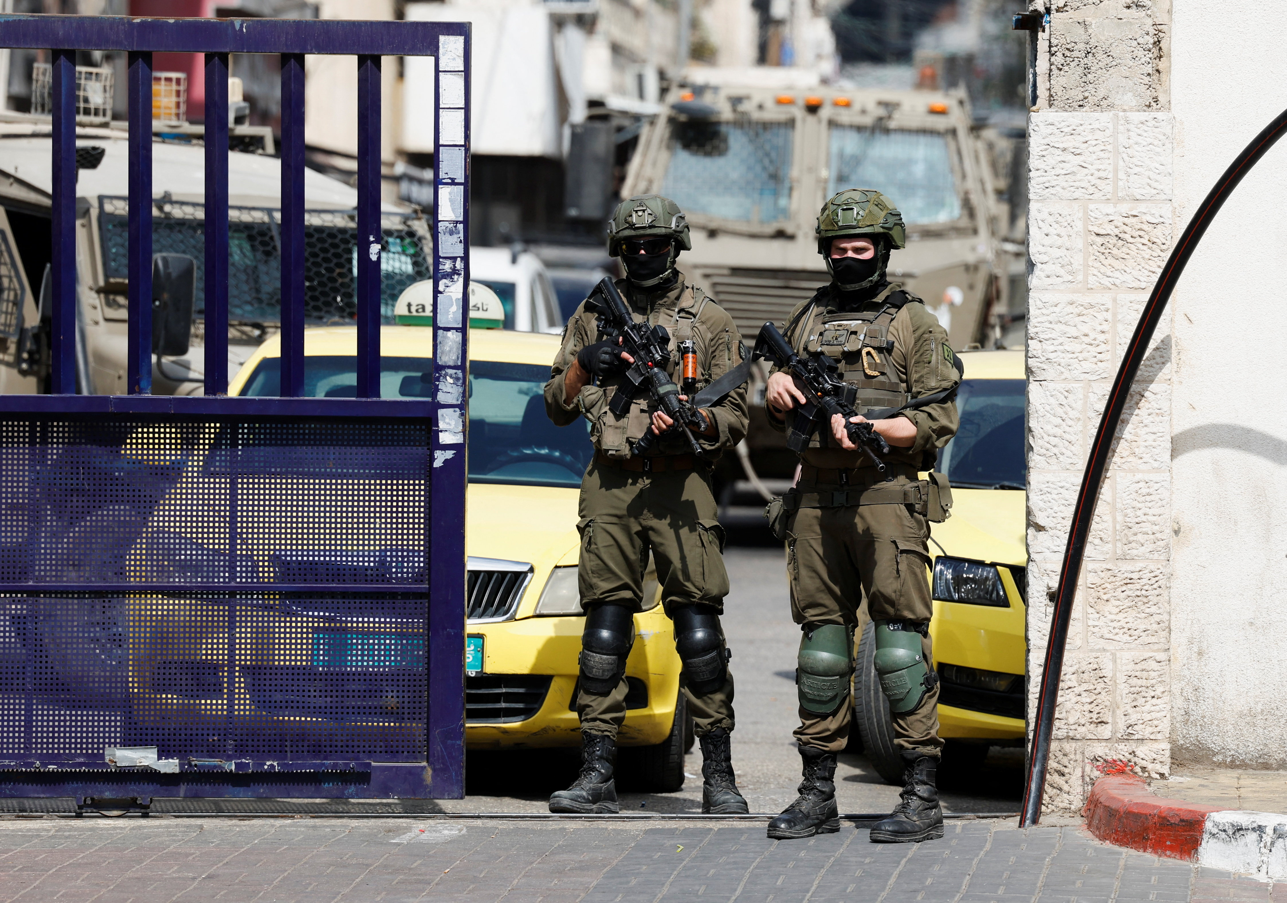Israeli soldiers stand guard during a raid.